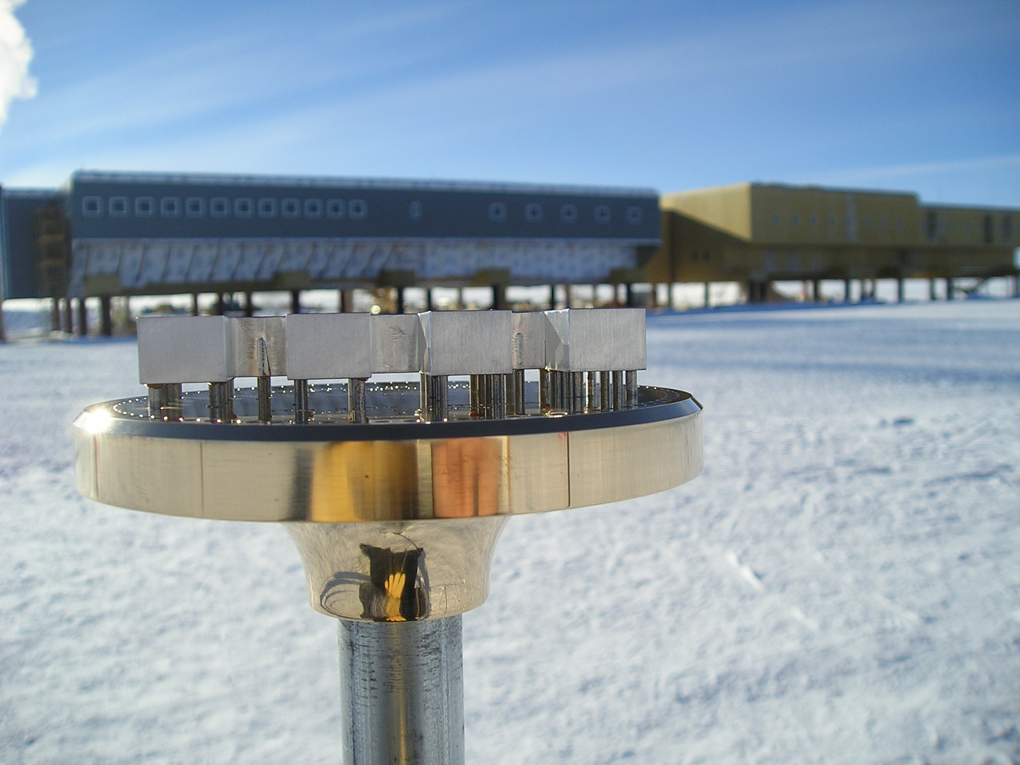 Metal object in foreground, building in background.