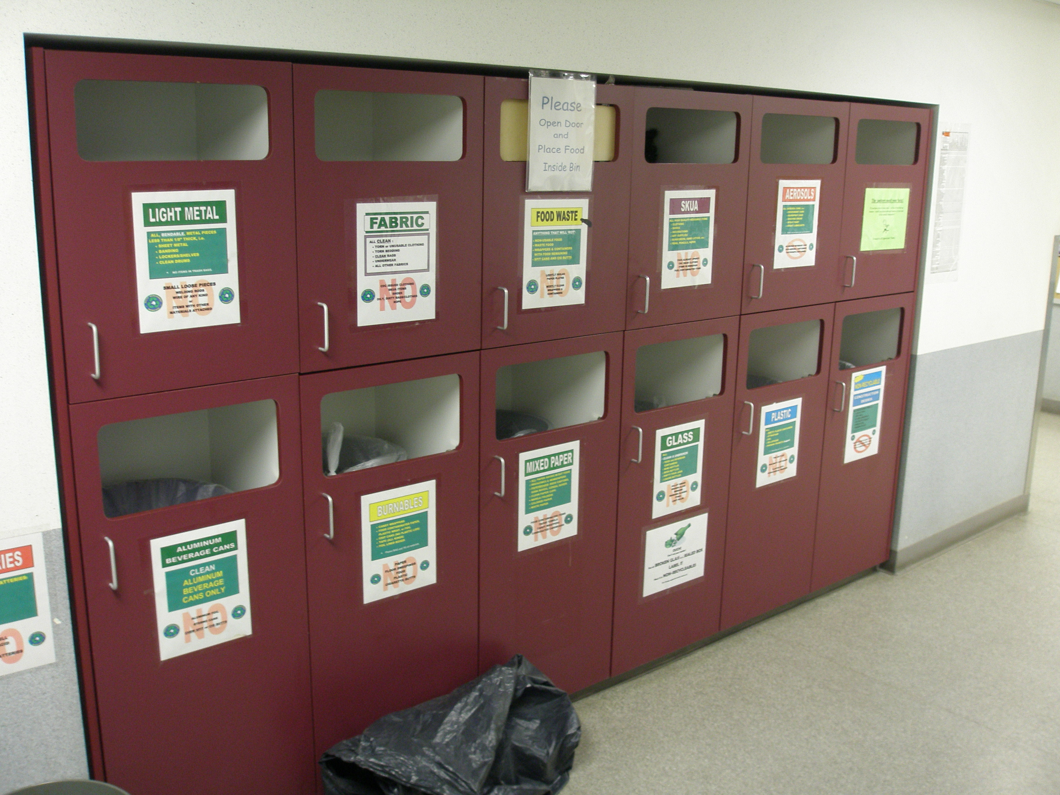 Indoor recycling bins in a hallway.