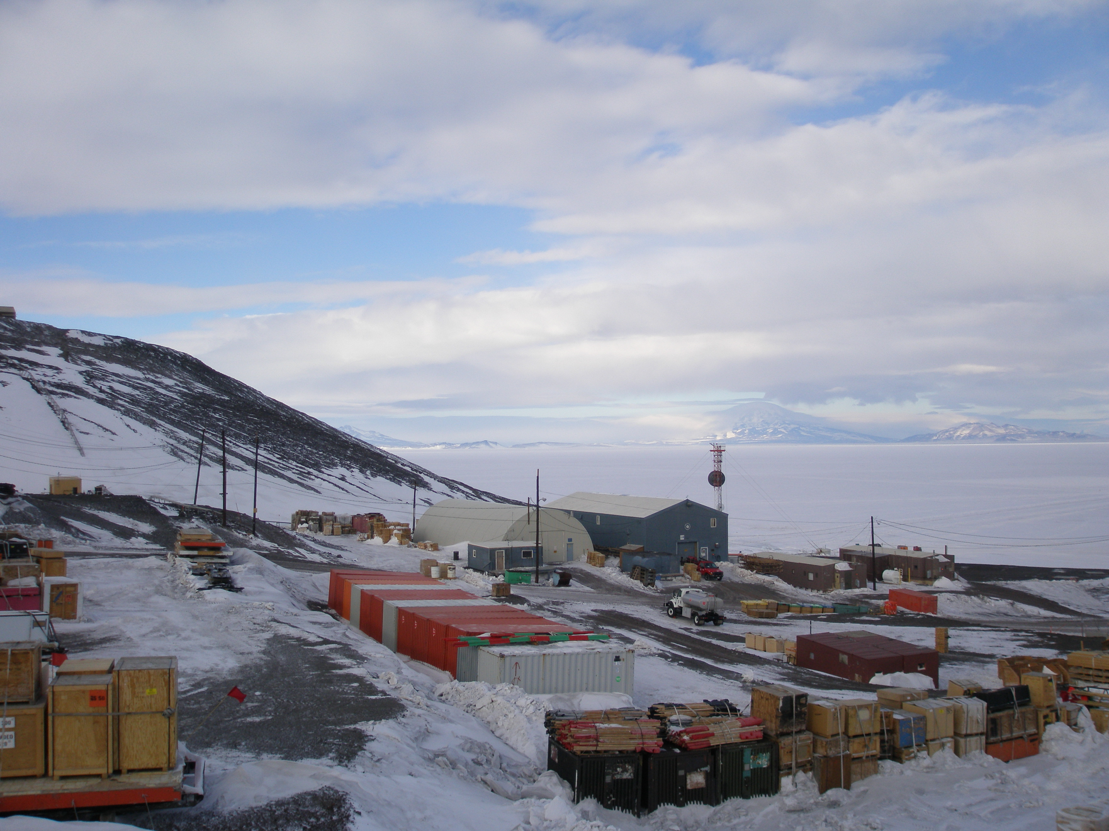 Cargo containers placed outside buildings on snow-covered ground.