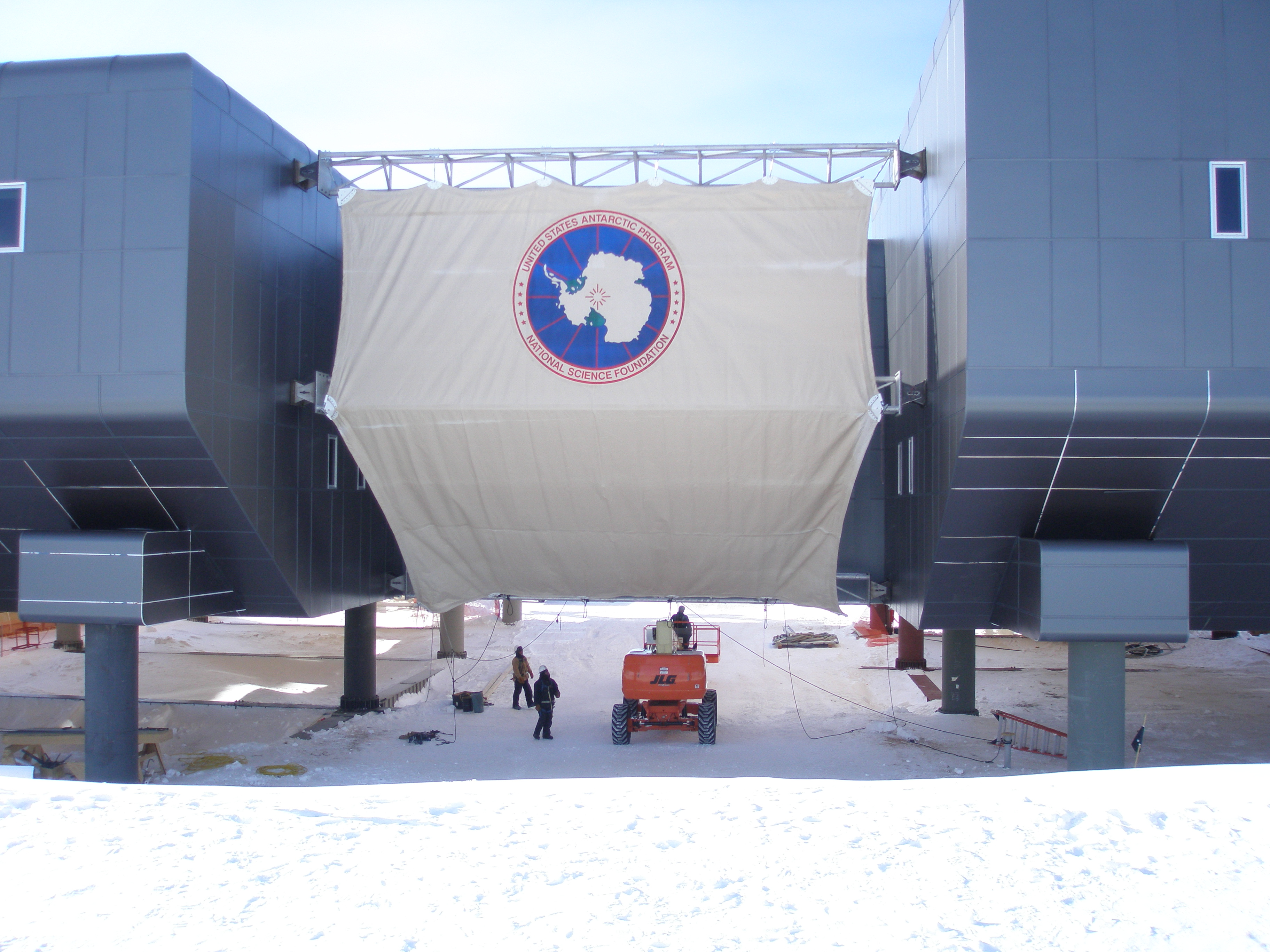 A large plastic sheet covers part of the outside of a building.