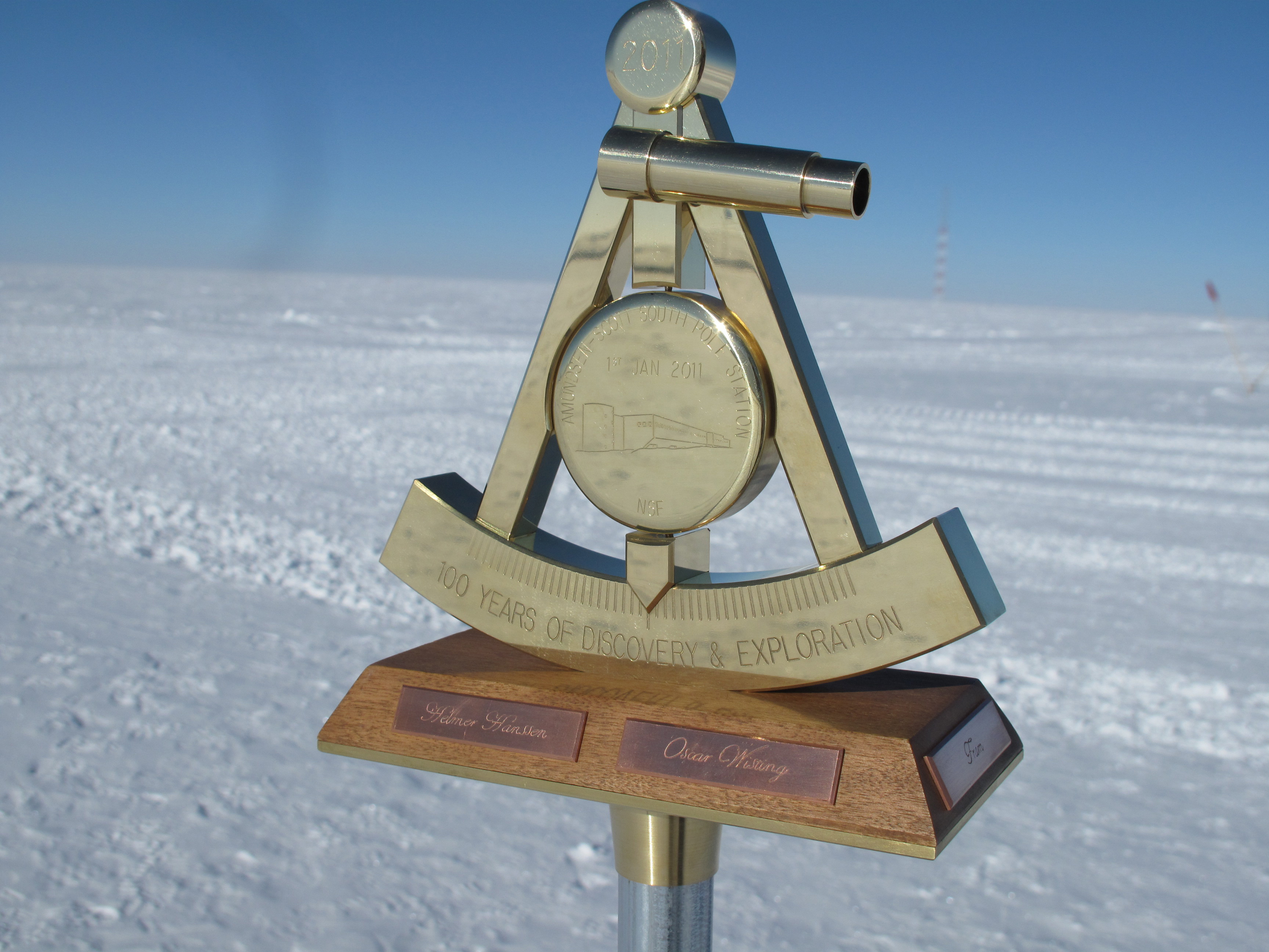 Bronze marker sits on top of a metal pole.