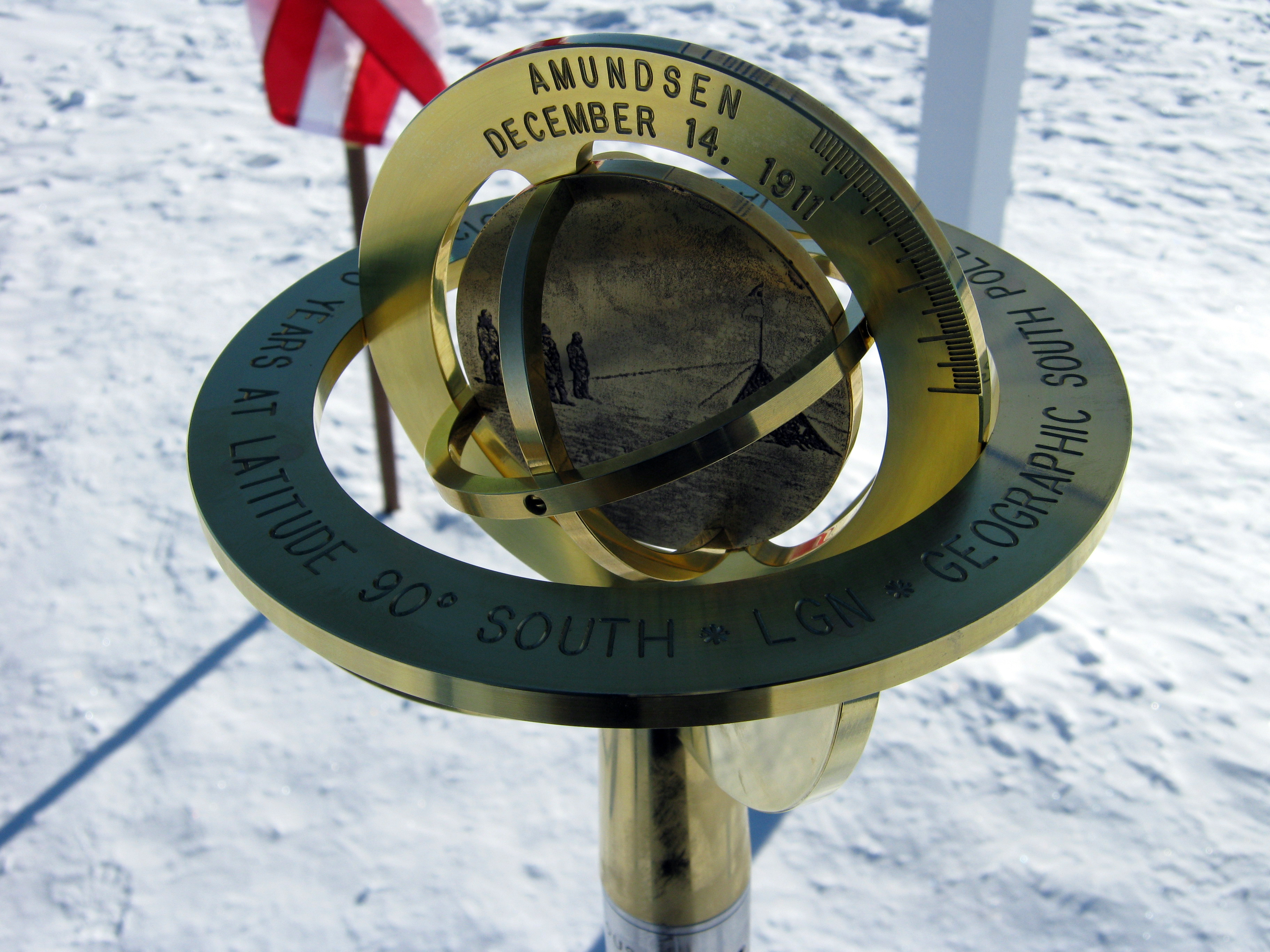 Brass pole marker stands in the snow.