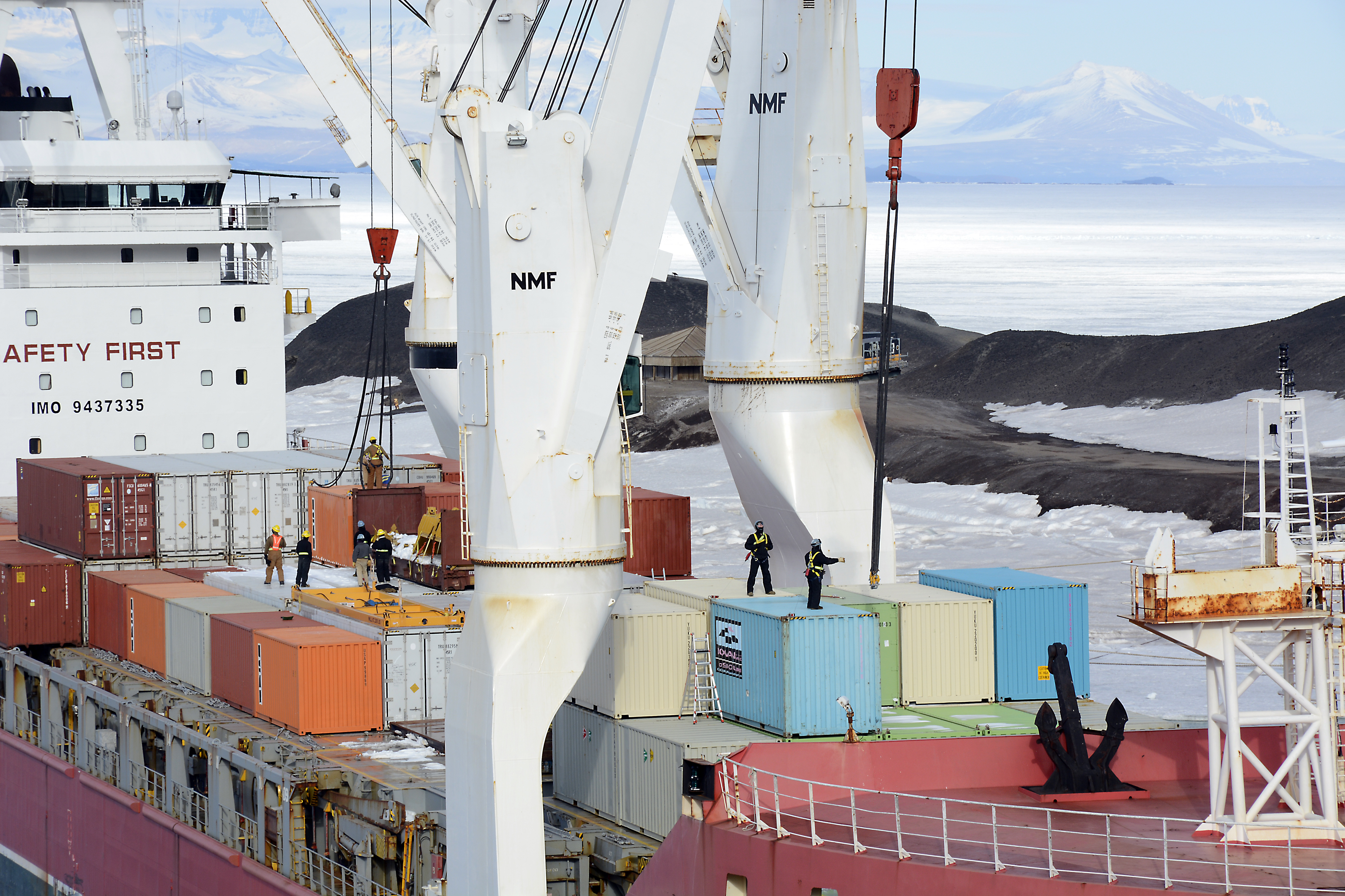 People work on a ship's cargo deck.