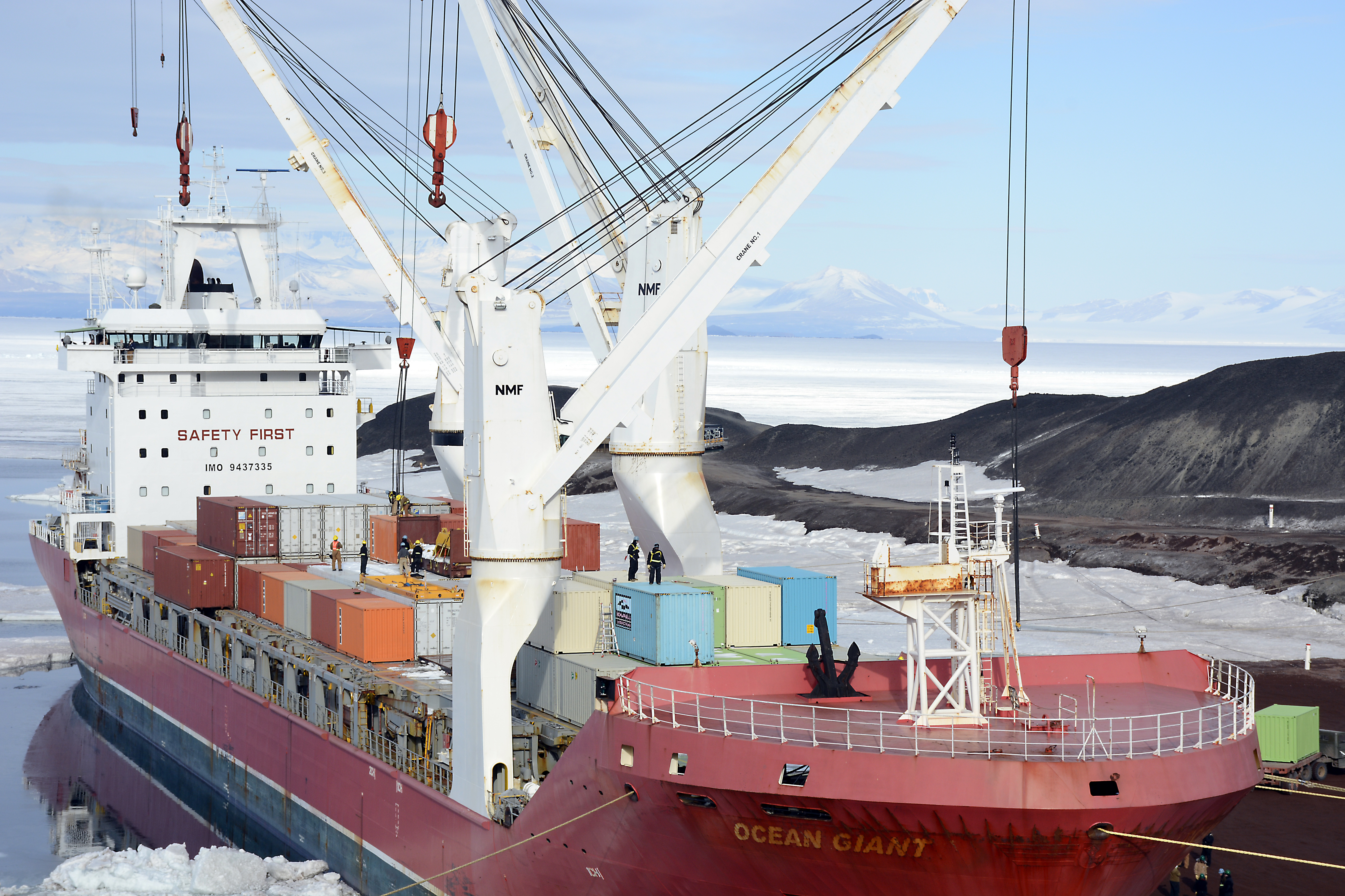 People work on a ship's cargo deck.