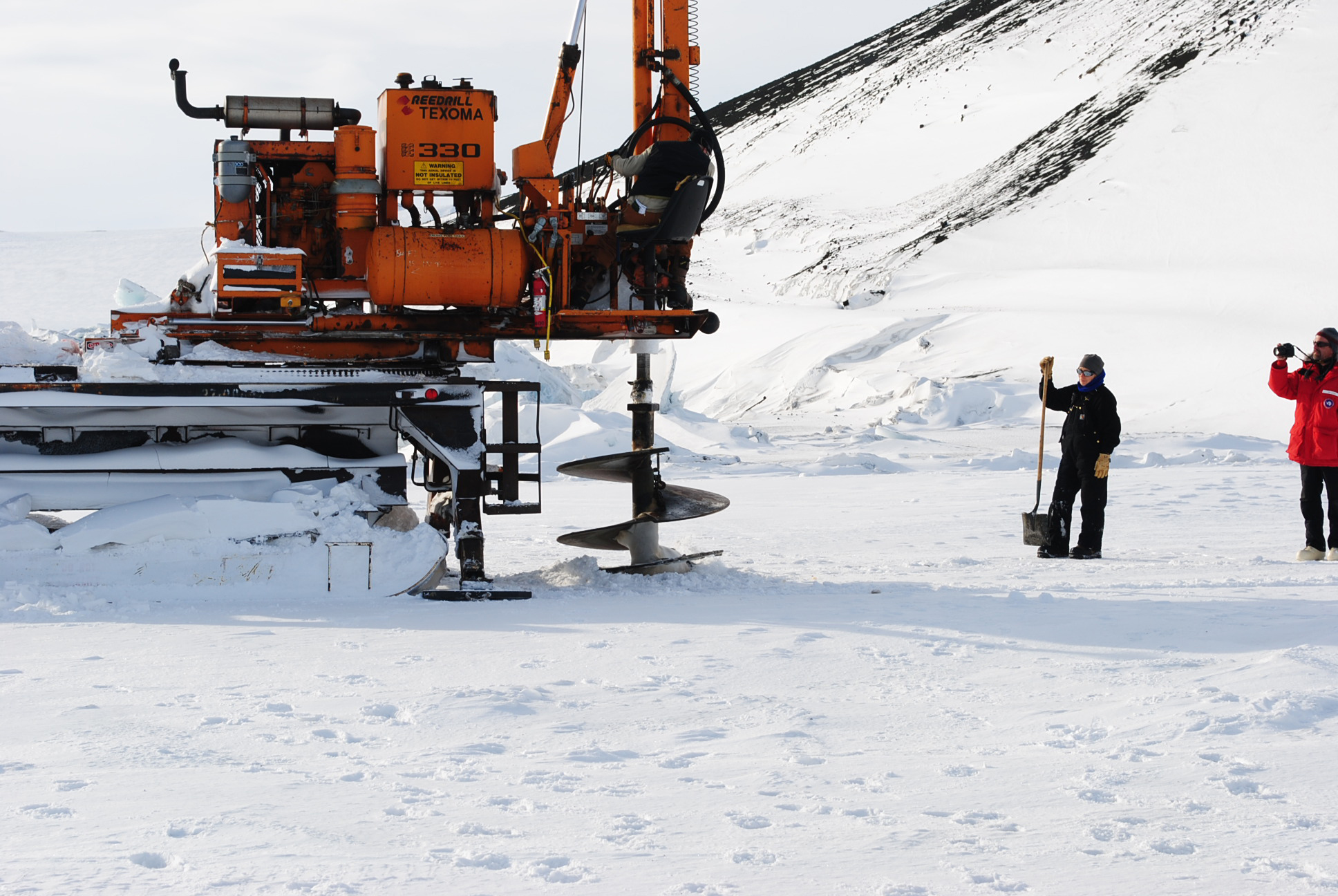 A large drill making a hole in the ice.