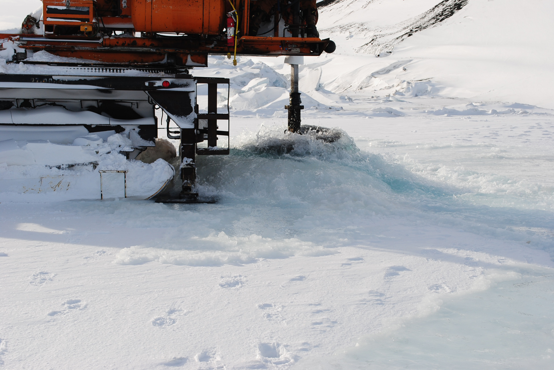 A large drill opening a hole in the ice.