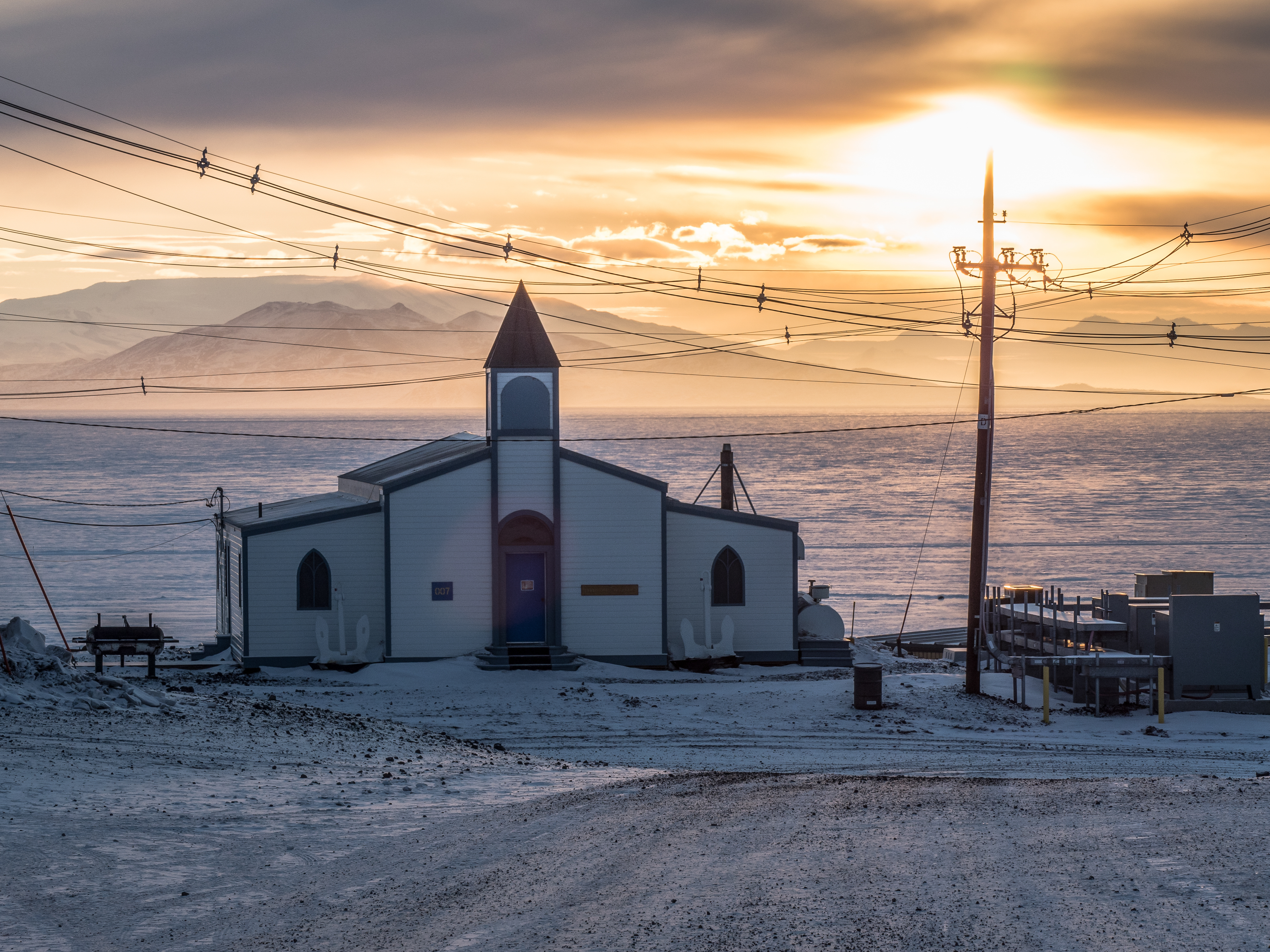 The sun setting behind a church.