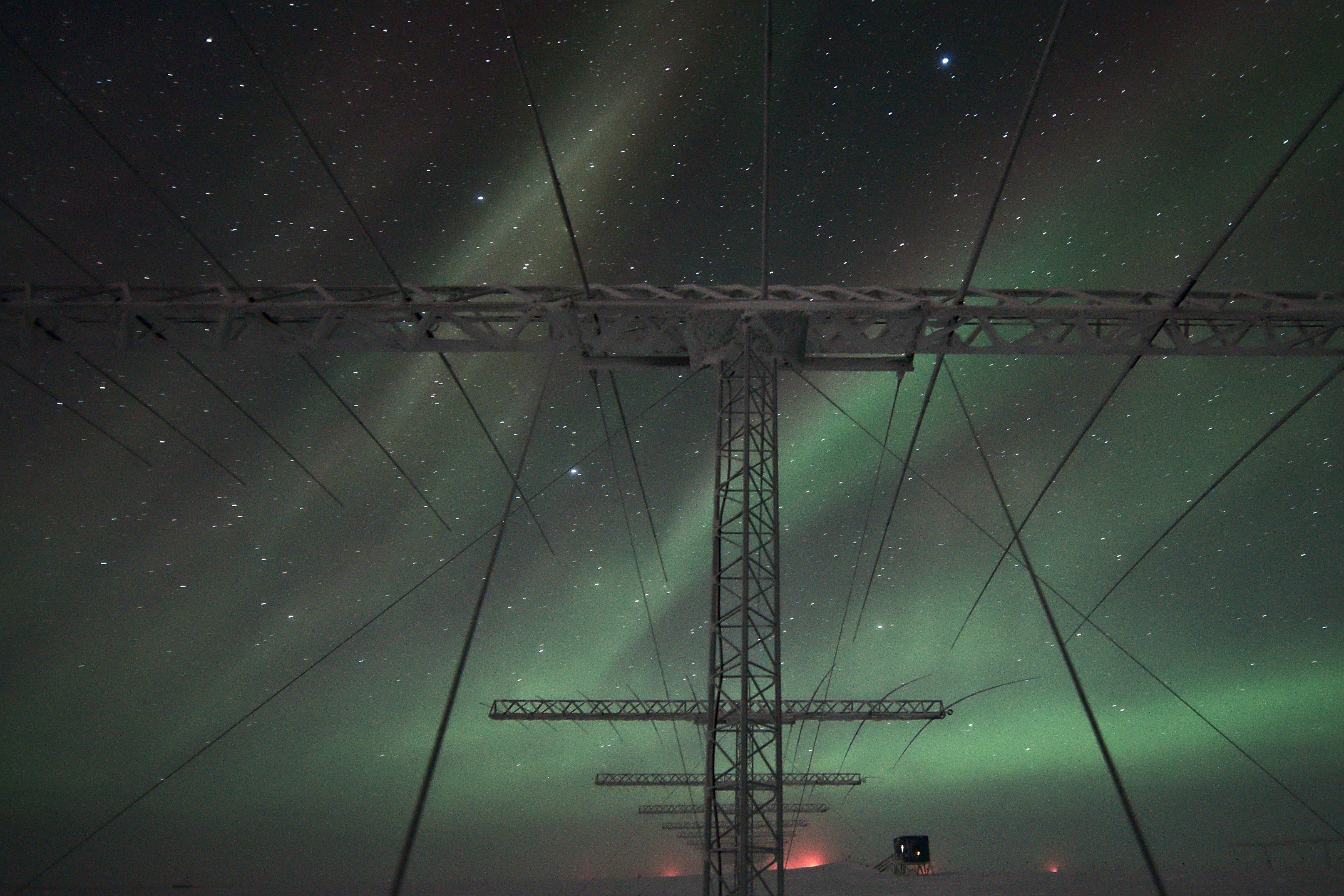 Auroras in the night sky over antennae.