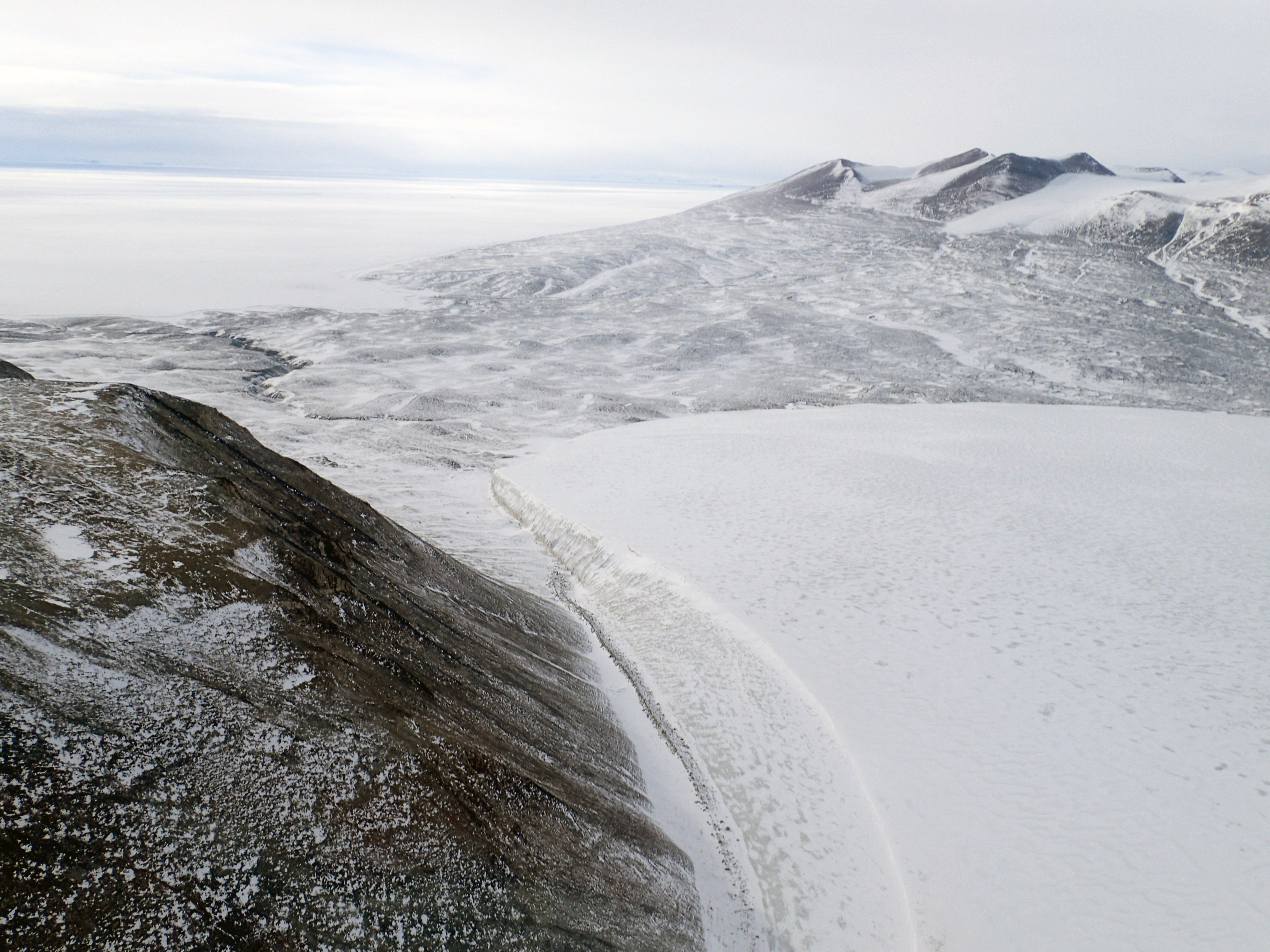 Aerial view of a glacier pouring into a valley.