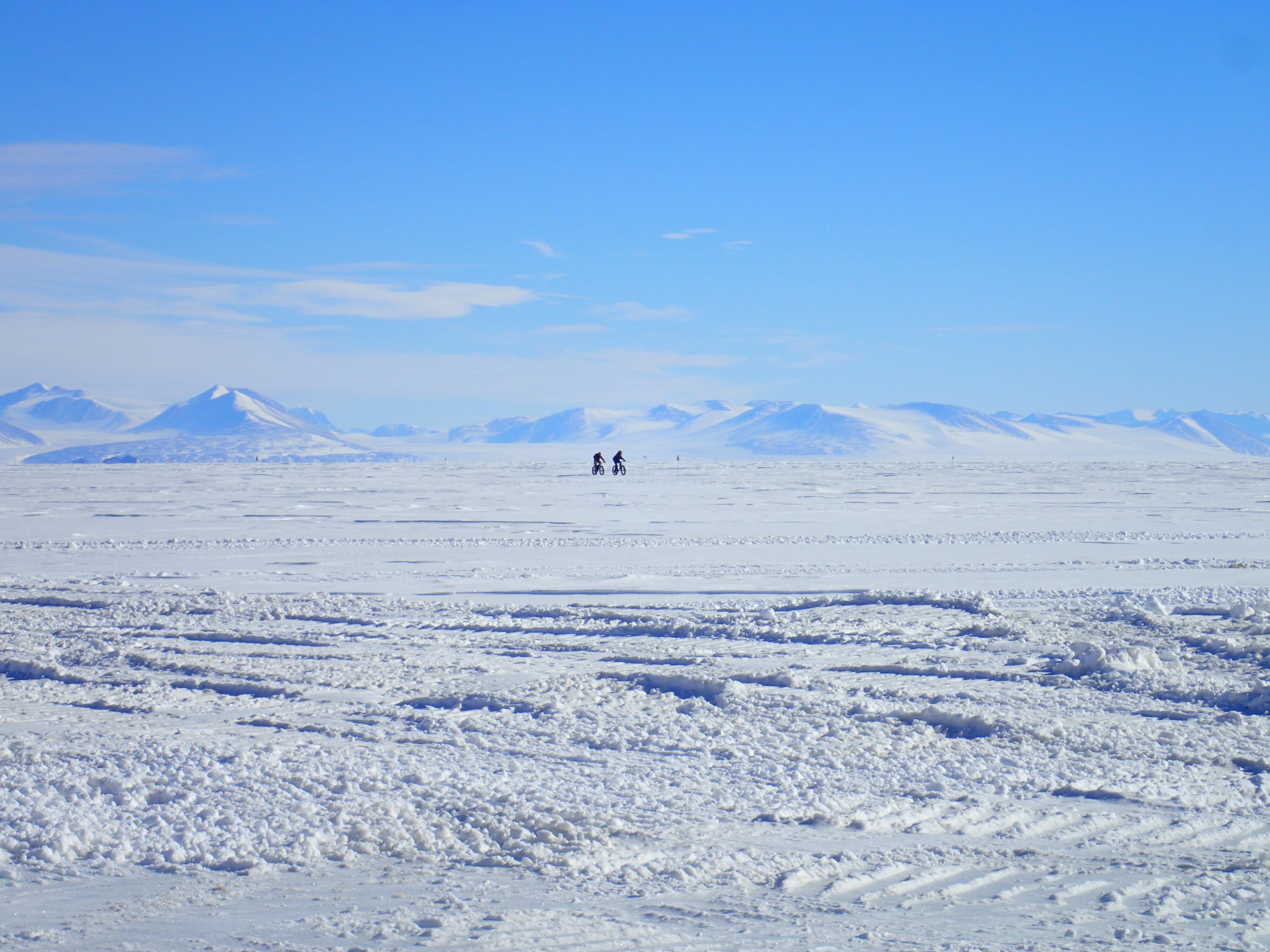 Two bicyclists on snow.