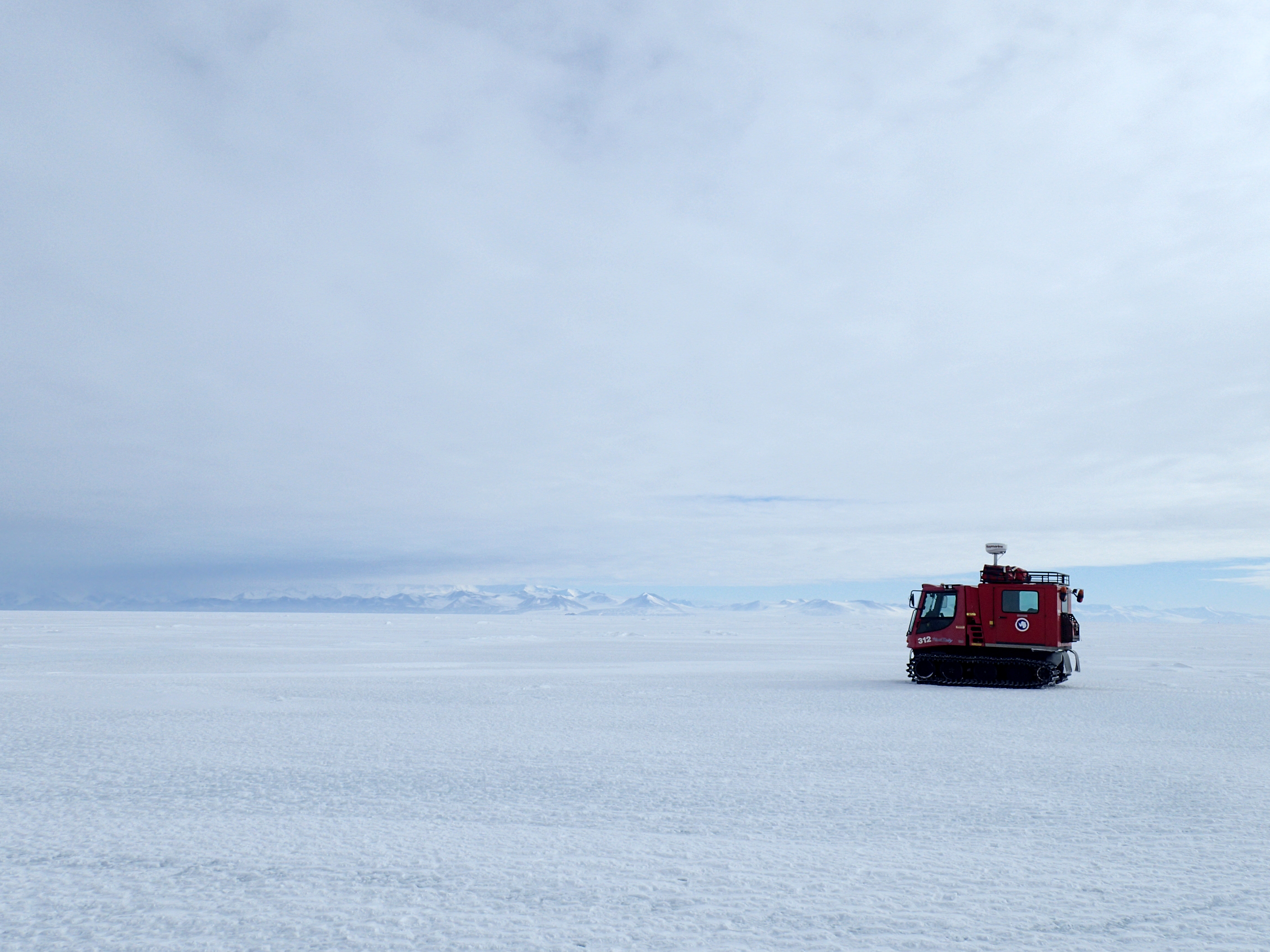 A small tracked vehicle on a snowy landscape.