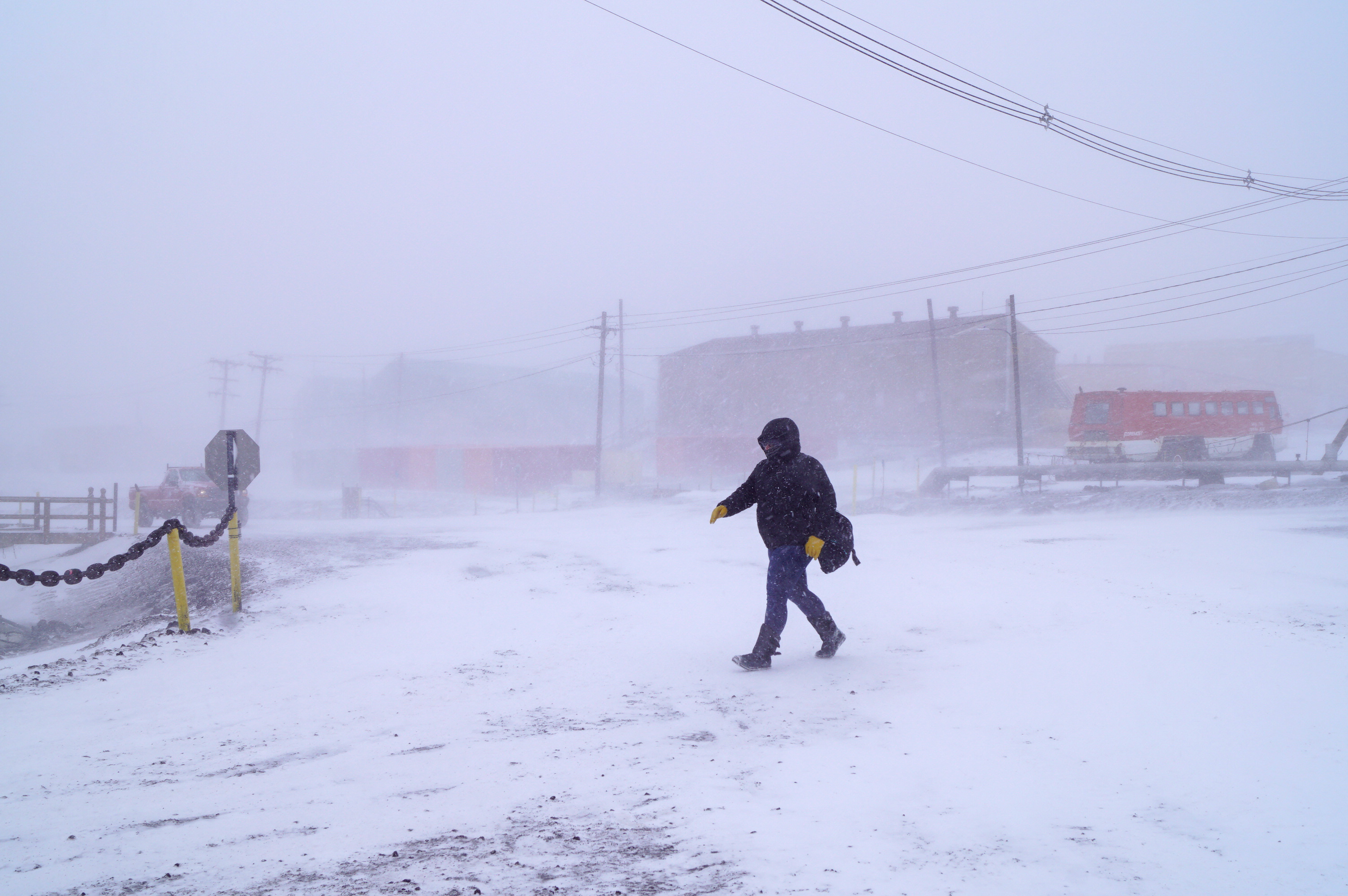 A person walking outside during a snow storm.