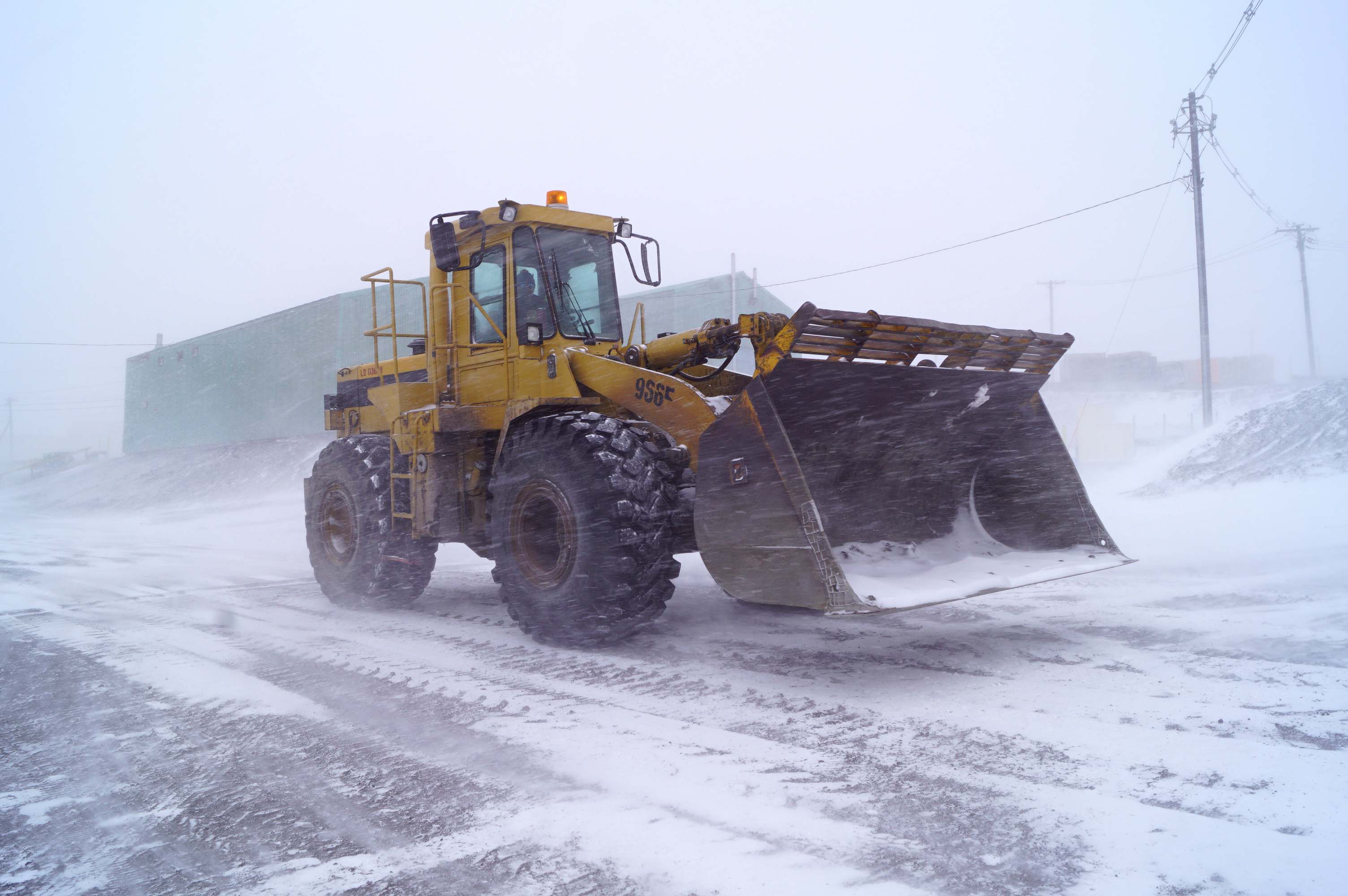 A large tractor in snowy weather.