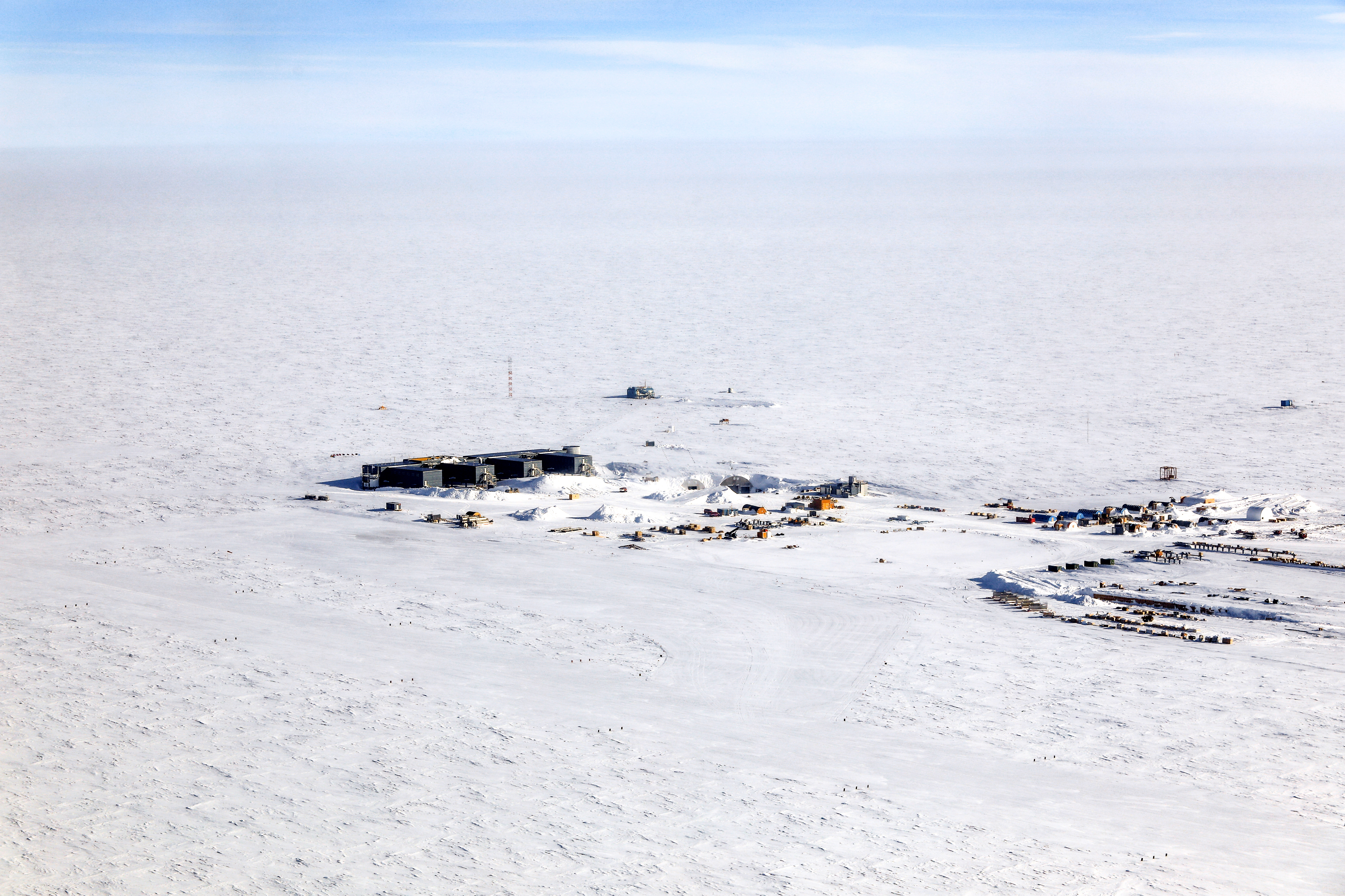 Buildings on flat white snowy landscape.