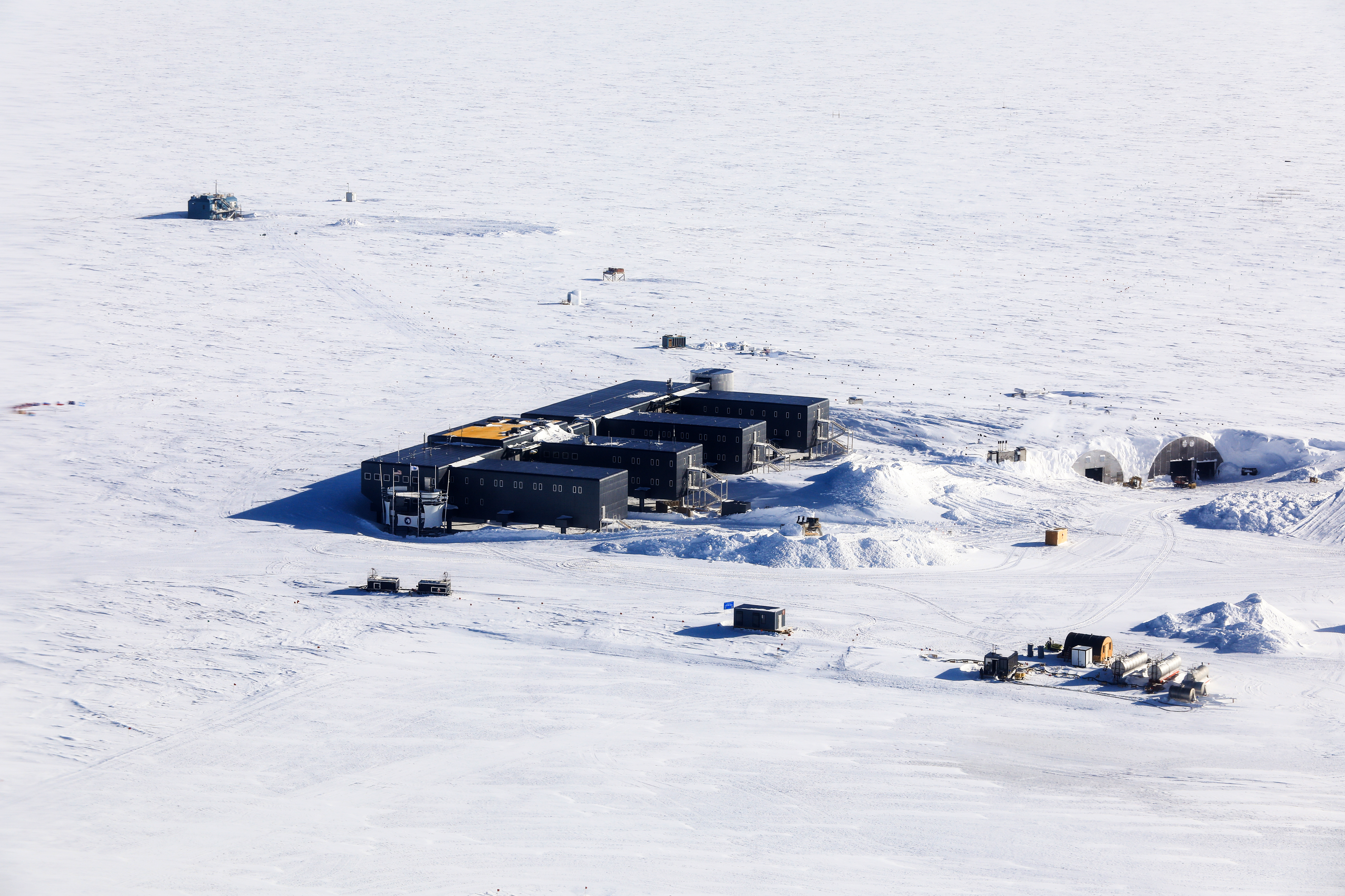 Buildings on flat white snowy landscape.