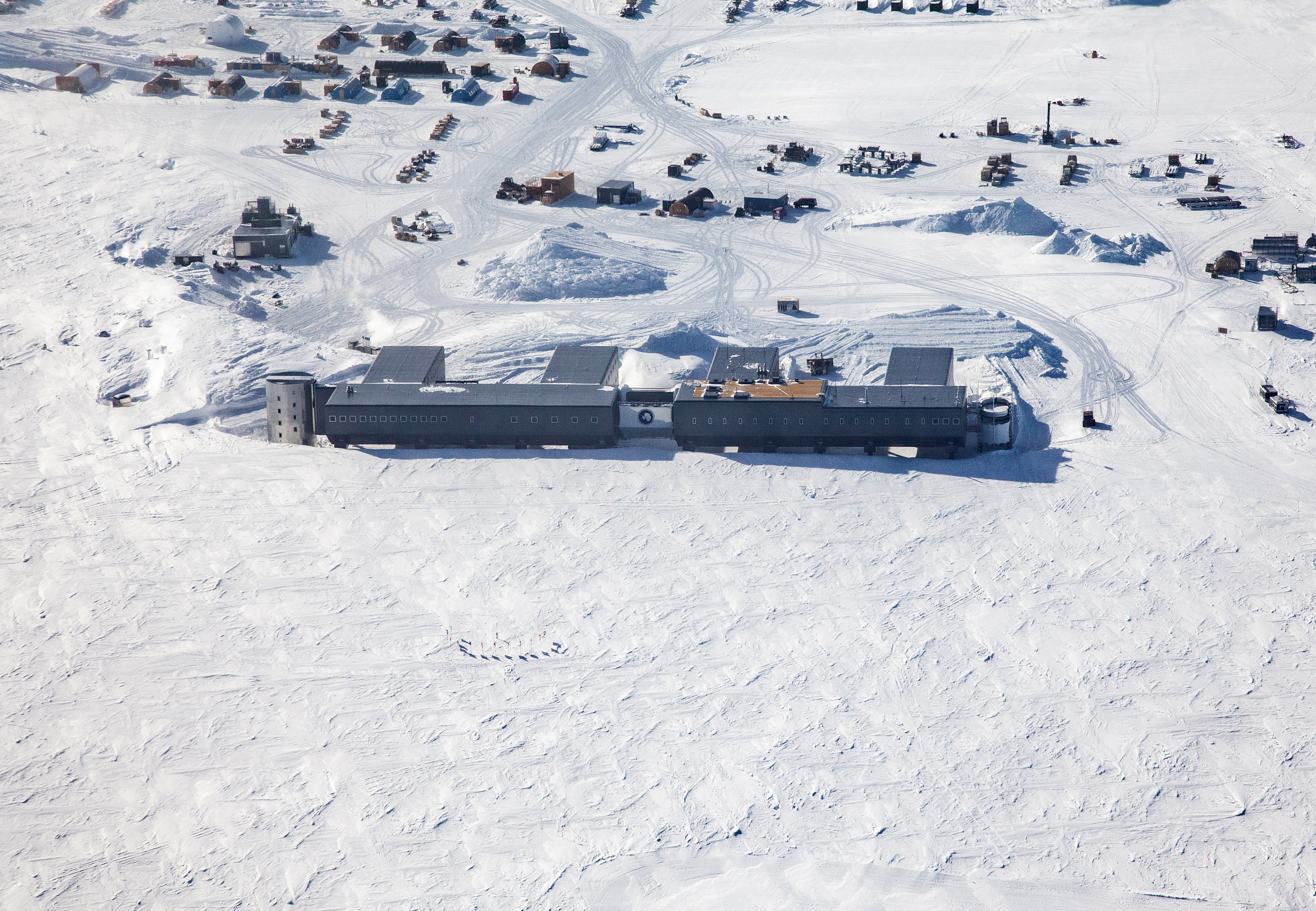 Buildings on flat white snowy landscape.