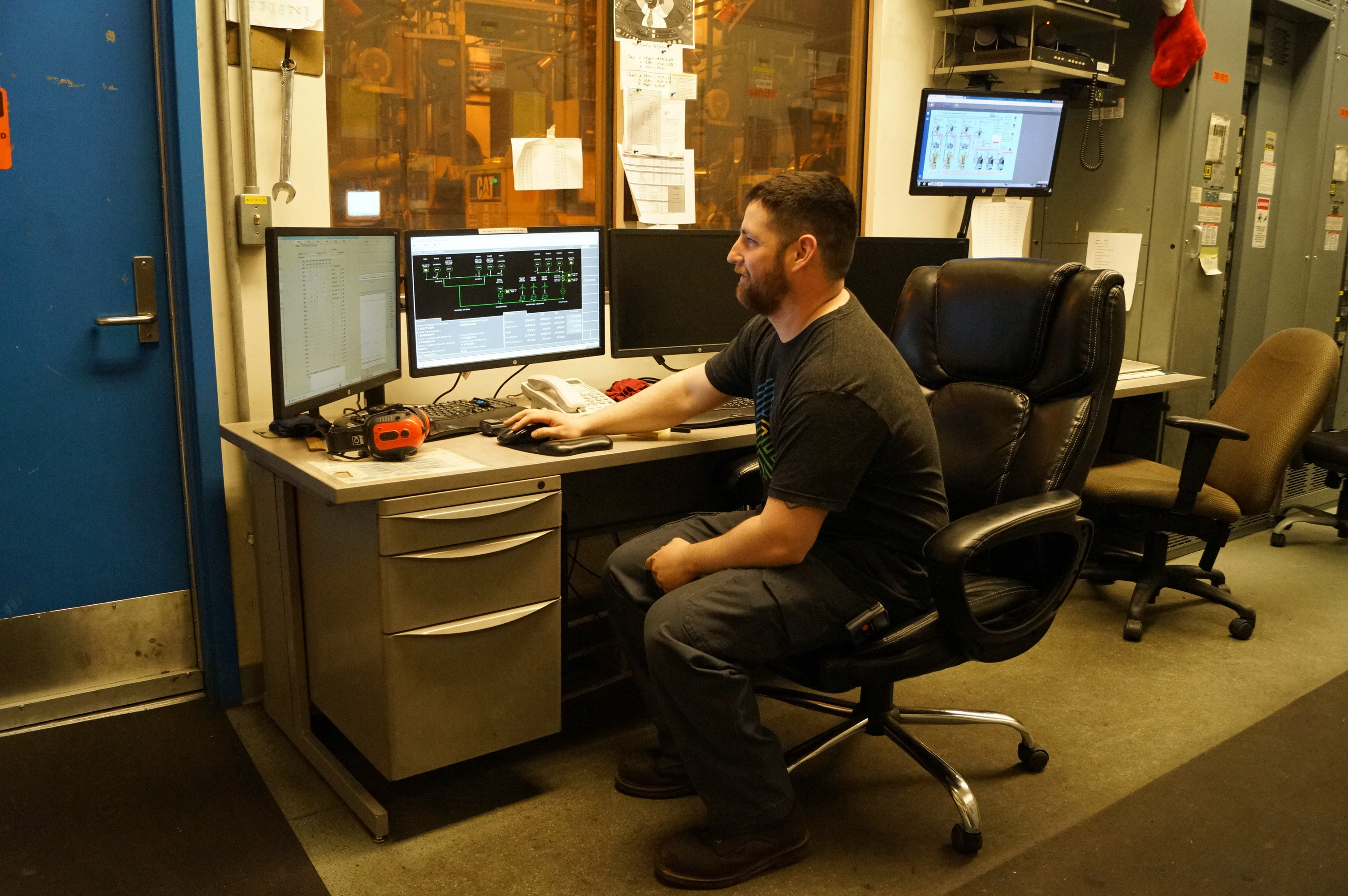 A man sits at a computer in an office.