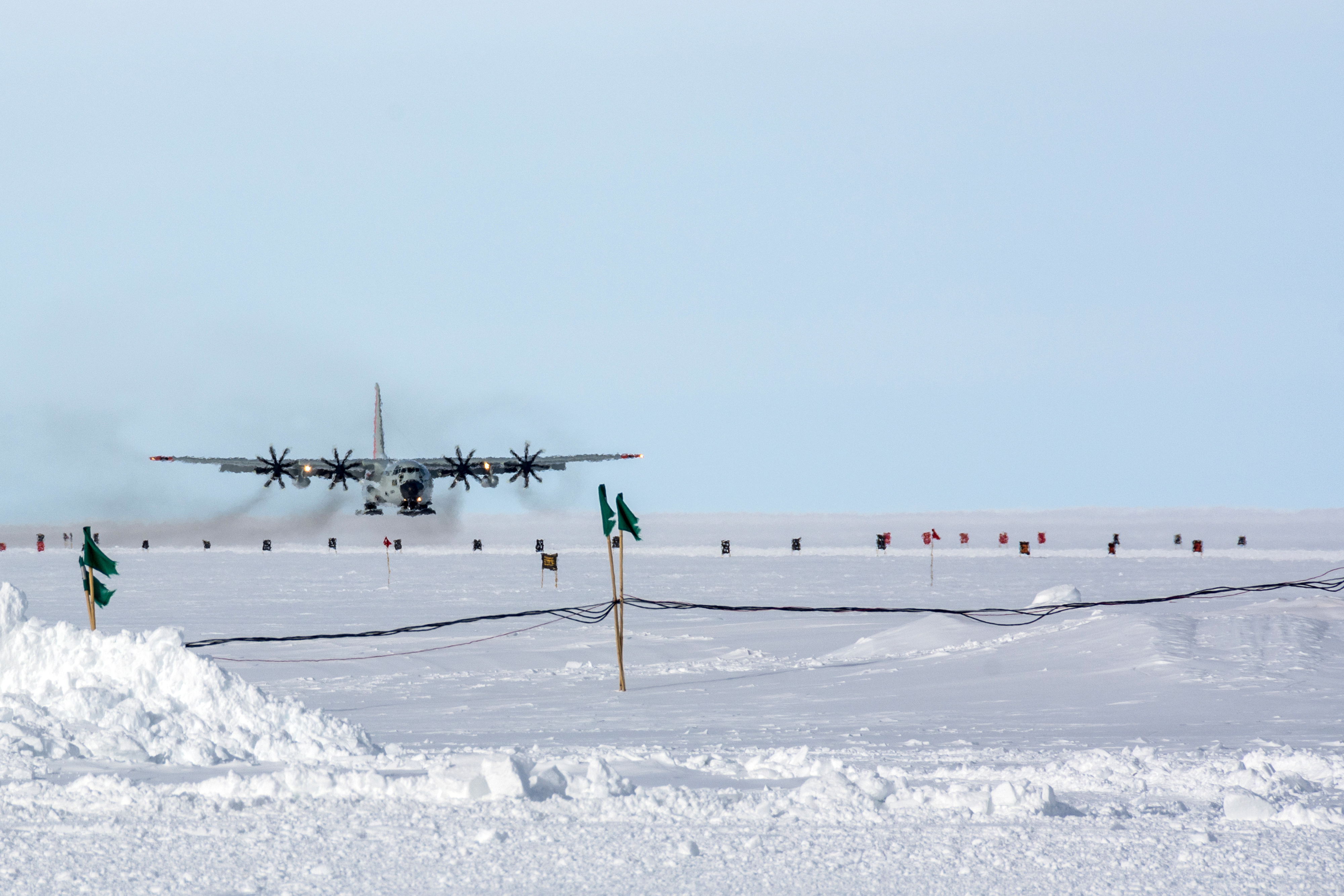 An airplane approaching a snow-covered runway.