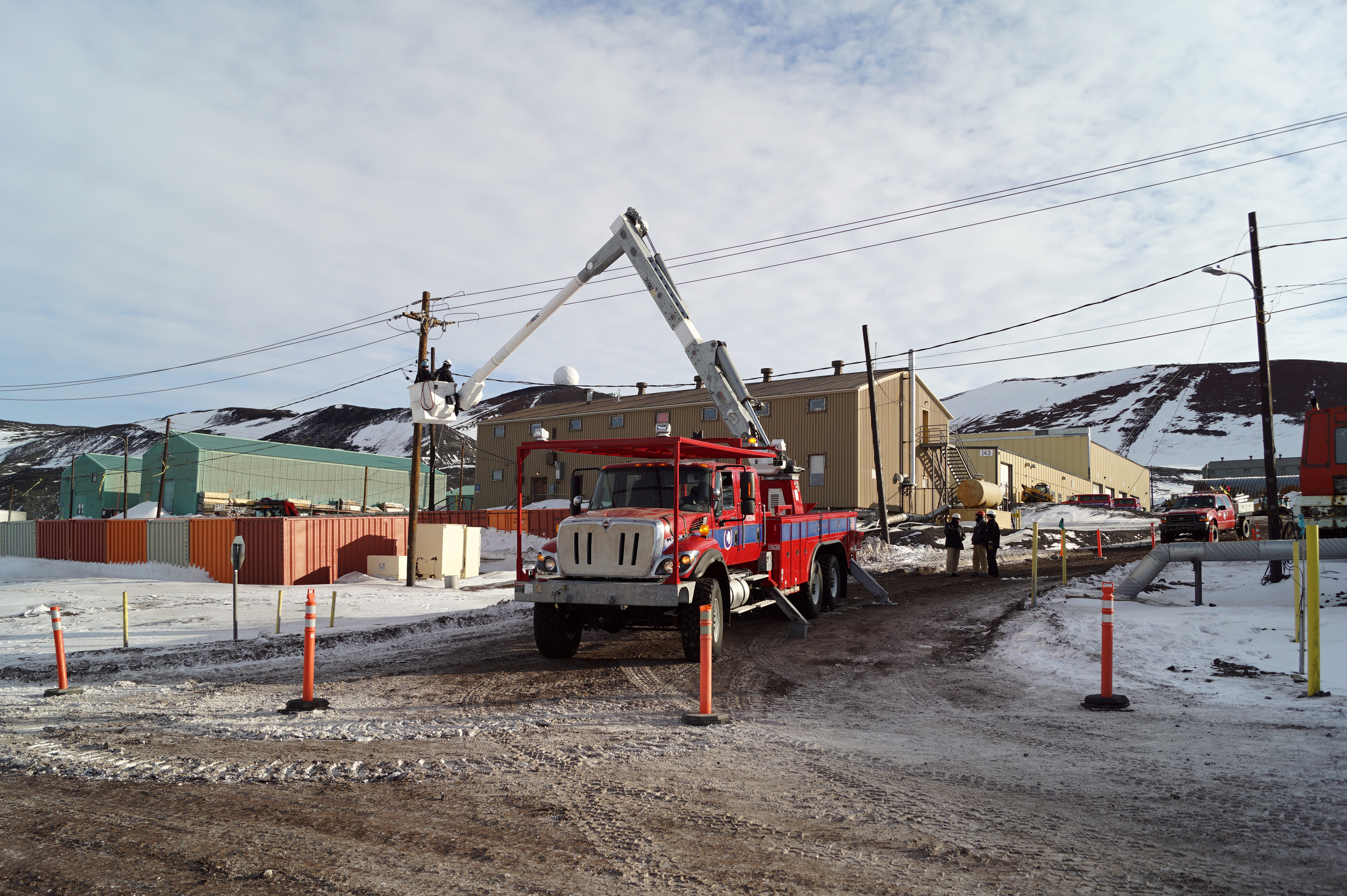 Men working from an electrical lineman's bucket truck.