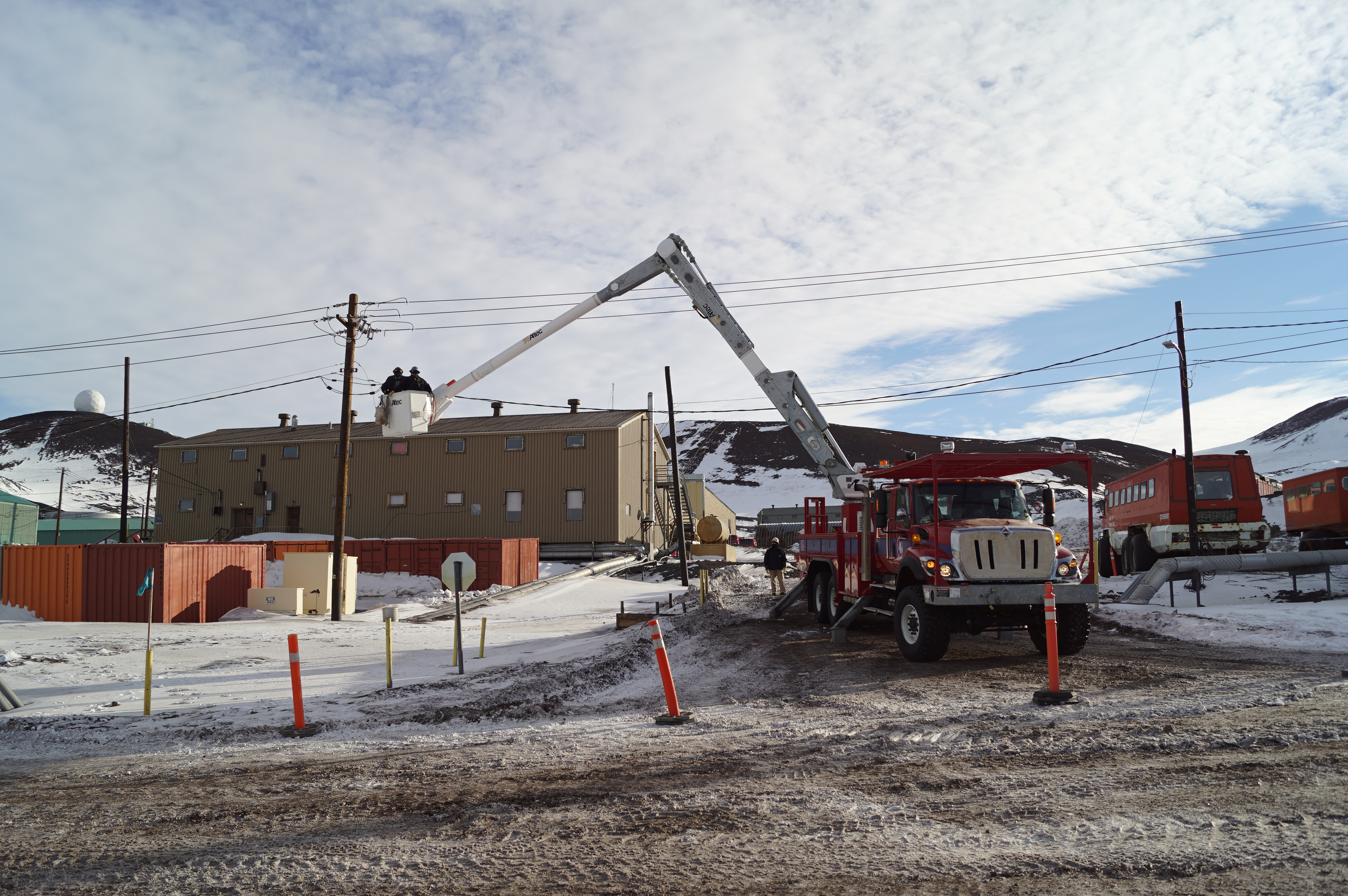 Men working from an electrical lineman's bucket truck.