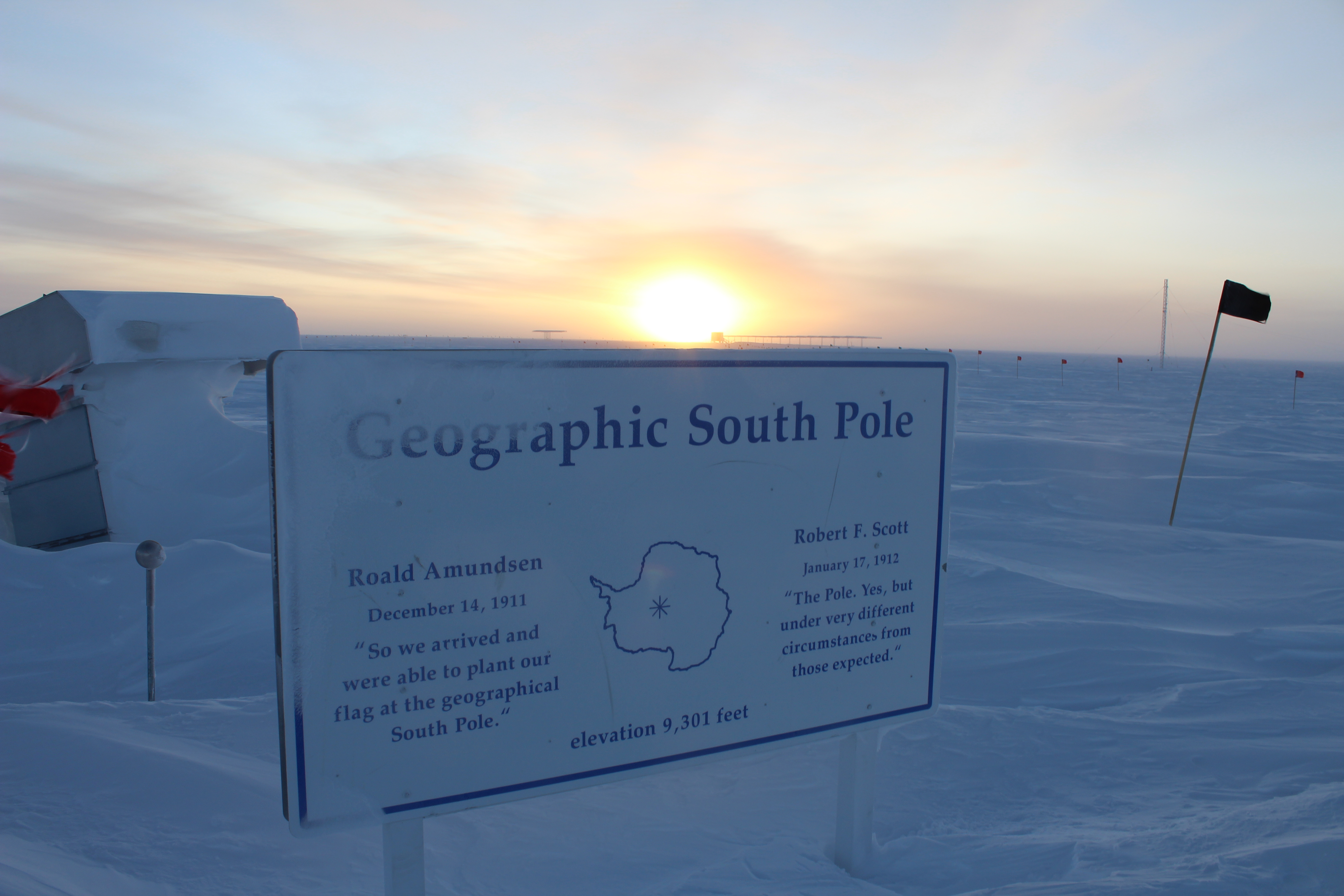 The sun begins to rise over a snowy landscape.