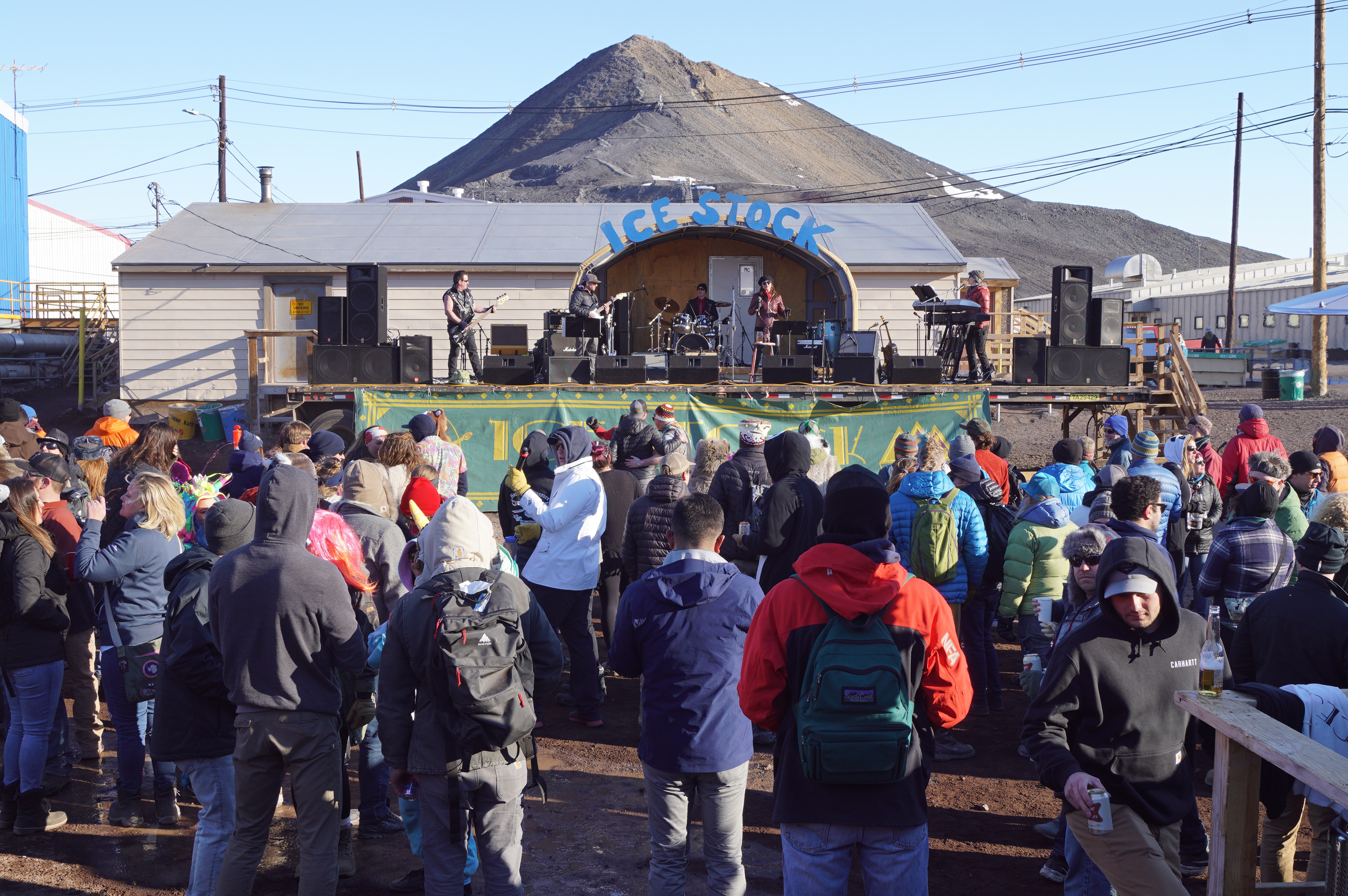 A crowd of people watching a band perform on a stage.