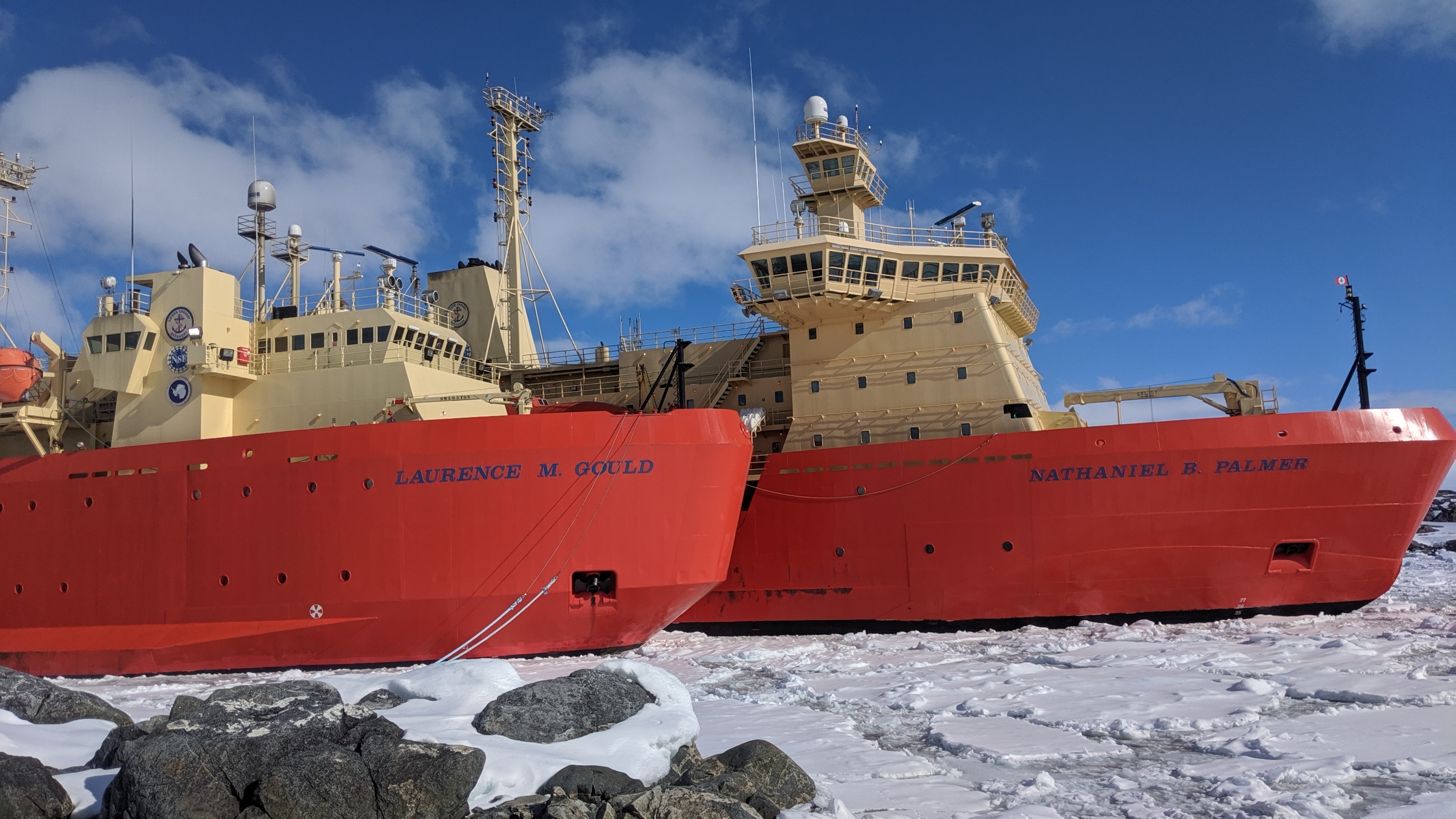 Two large ships in icy waters.