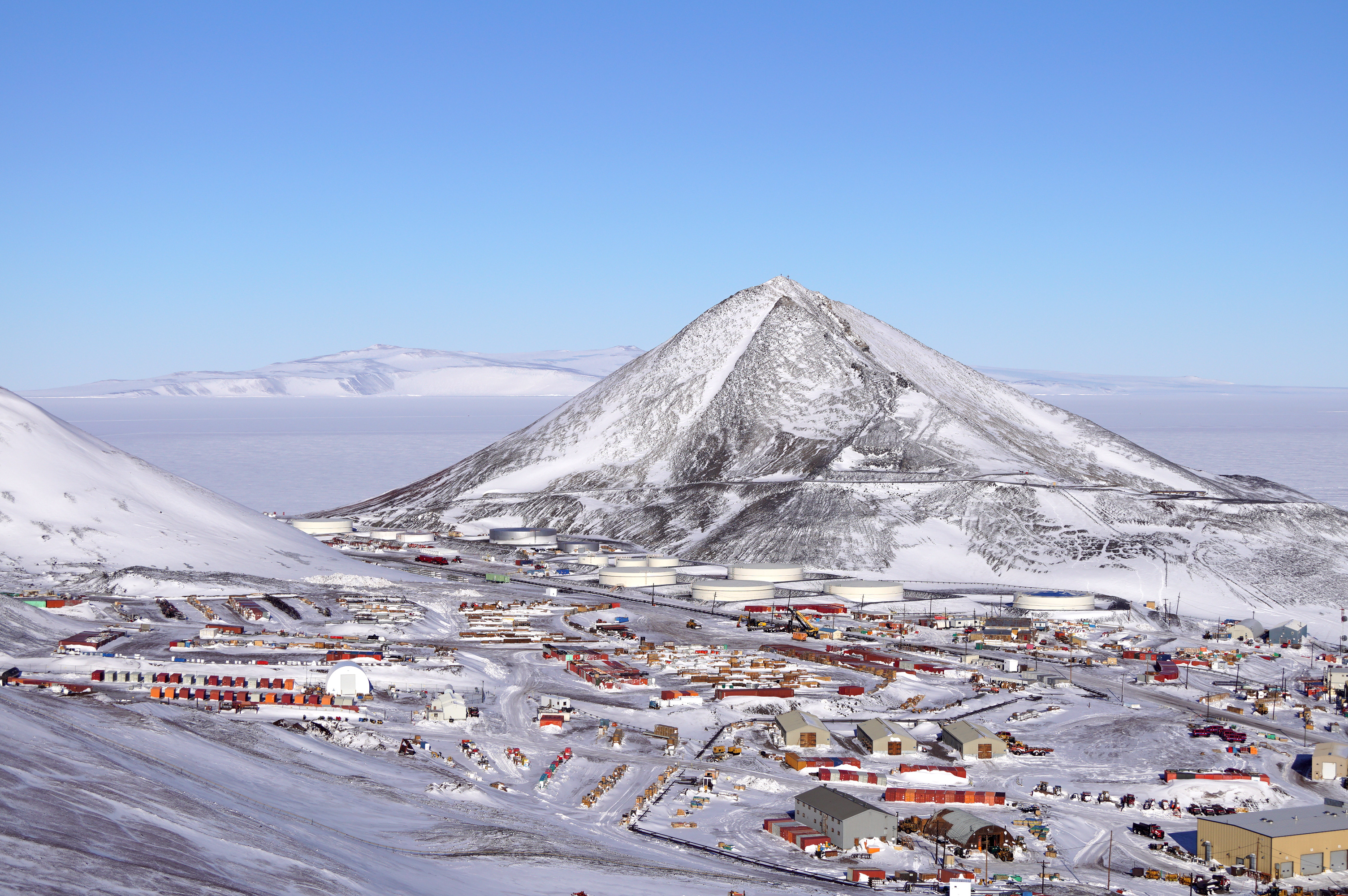 A view of a large hill with buildings at its base.