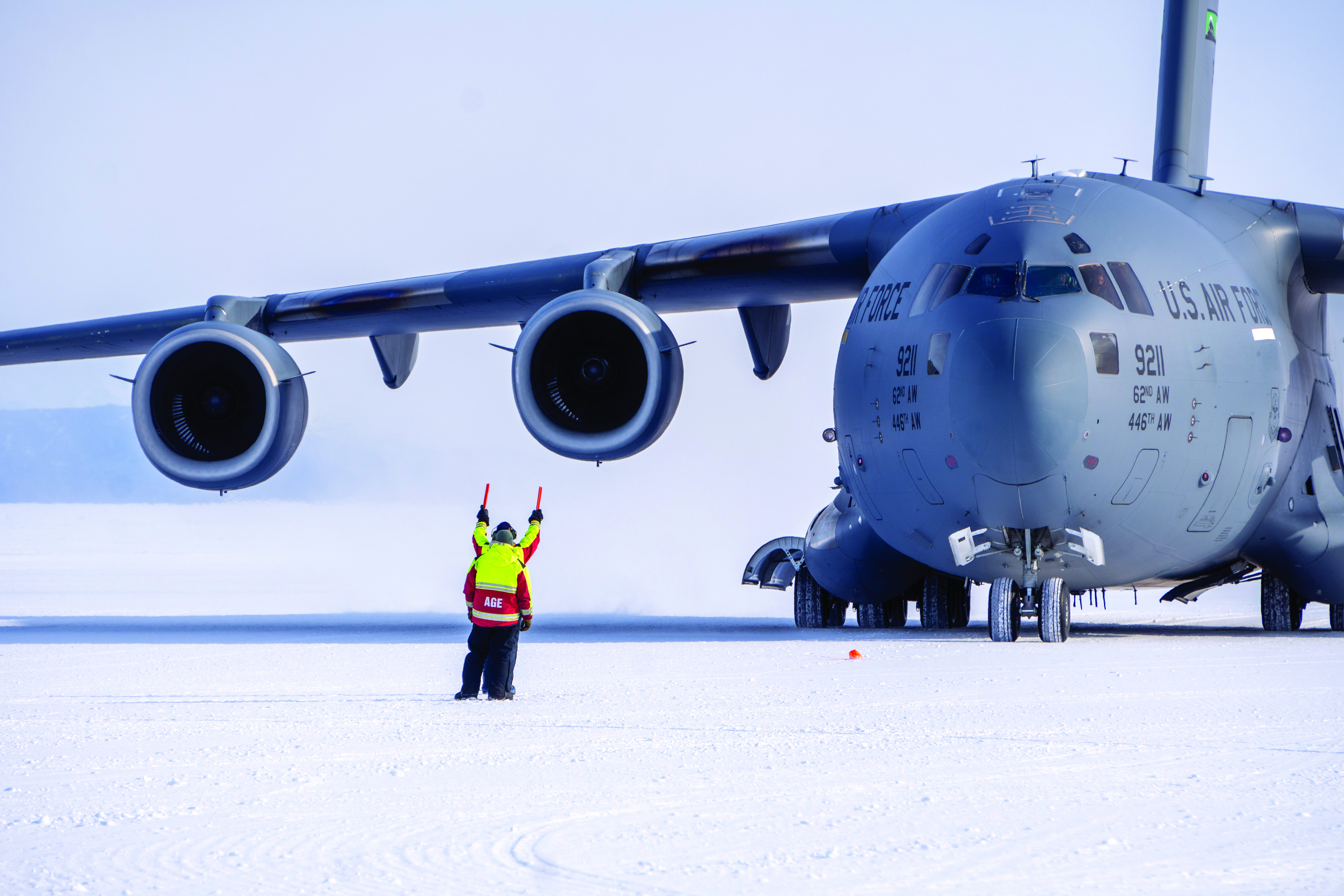 A person provides direction to a jet pilot.