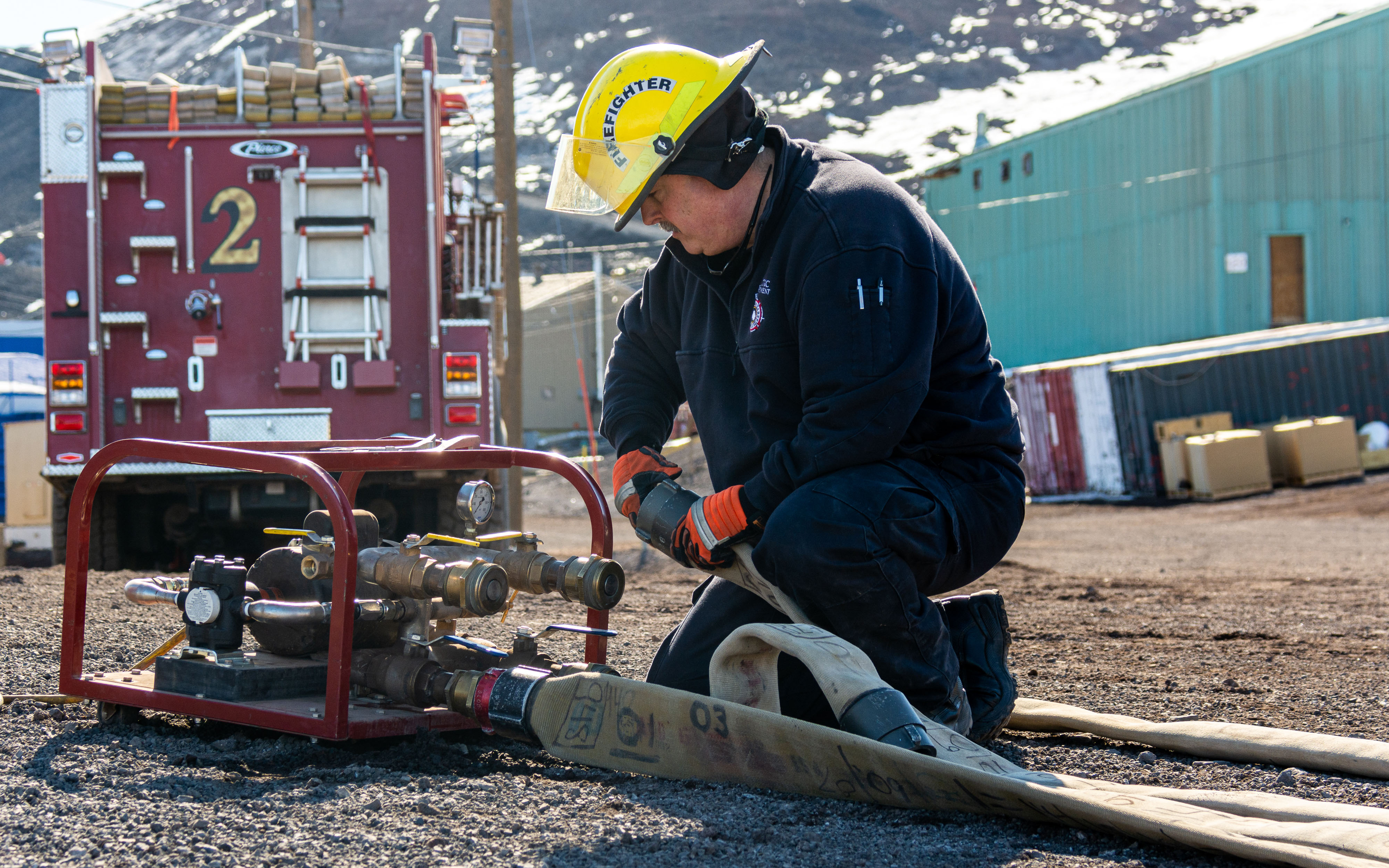 A firefighter works with a fire hose.