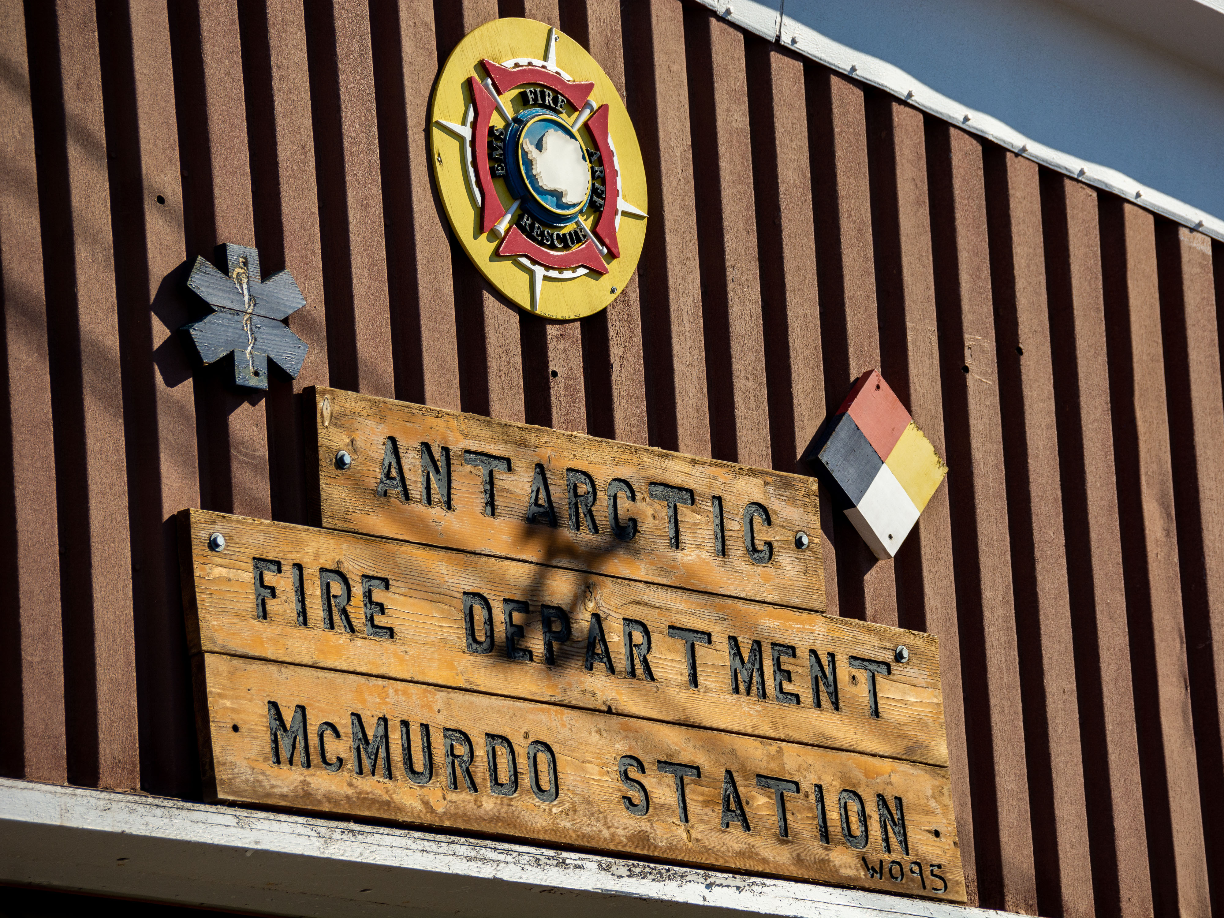 A sign on a building that says 'Antarctic Fire Department McMurdo Station.'