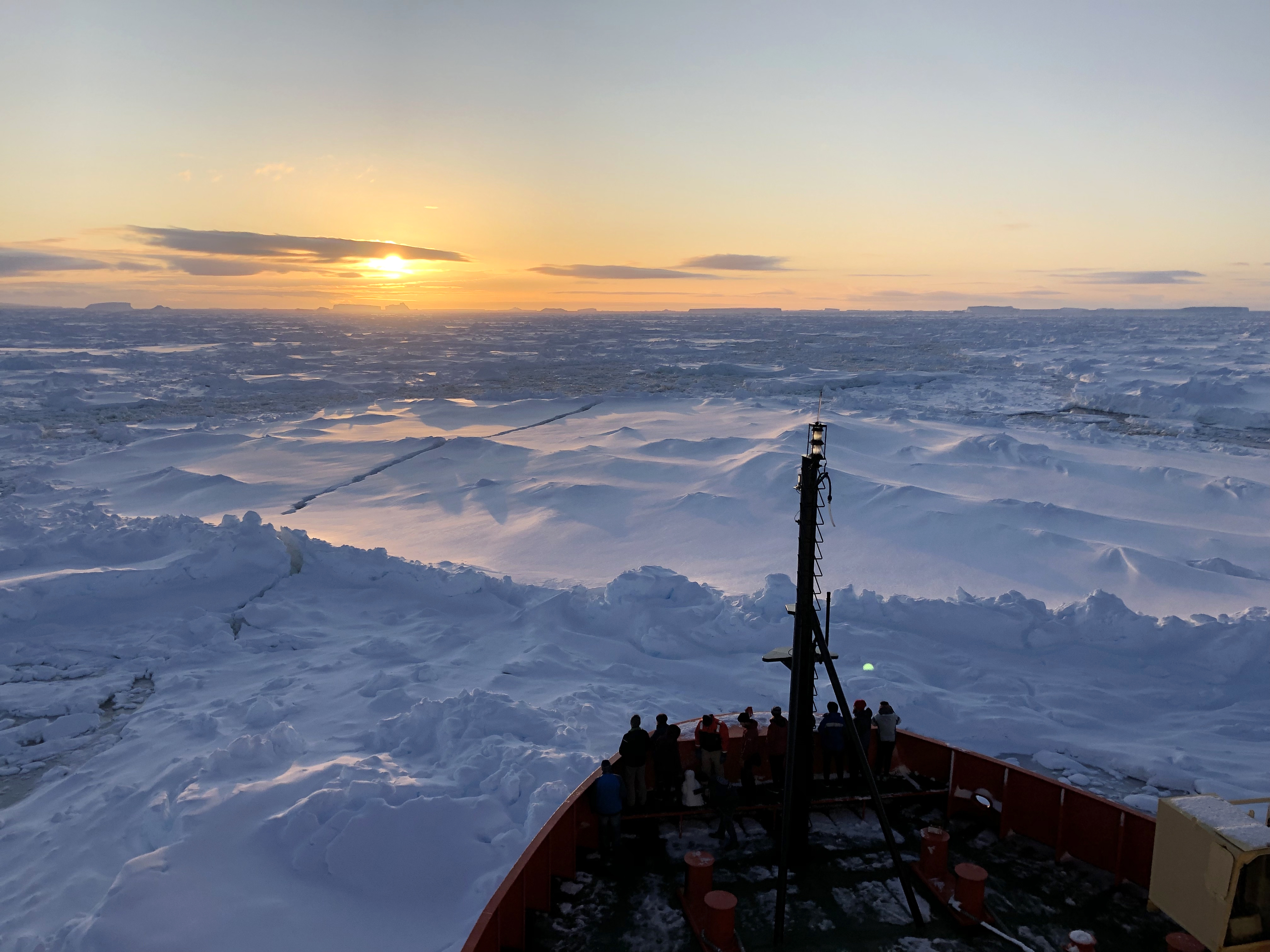 Sunrise over an ice-covered ocean.