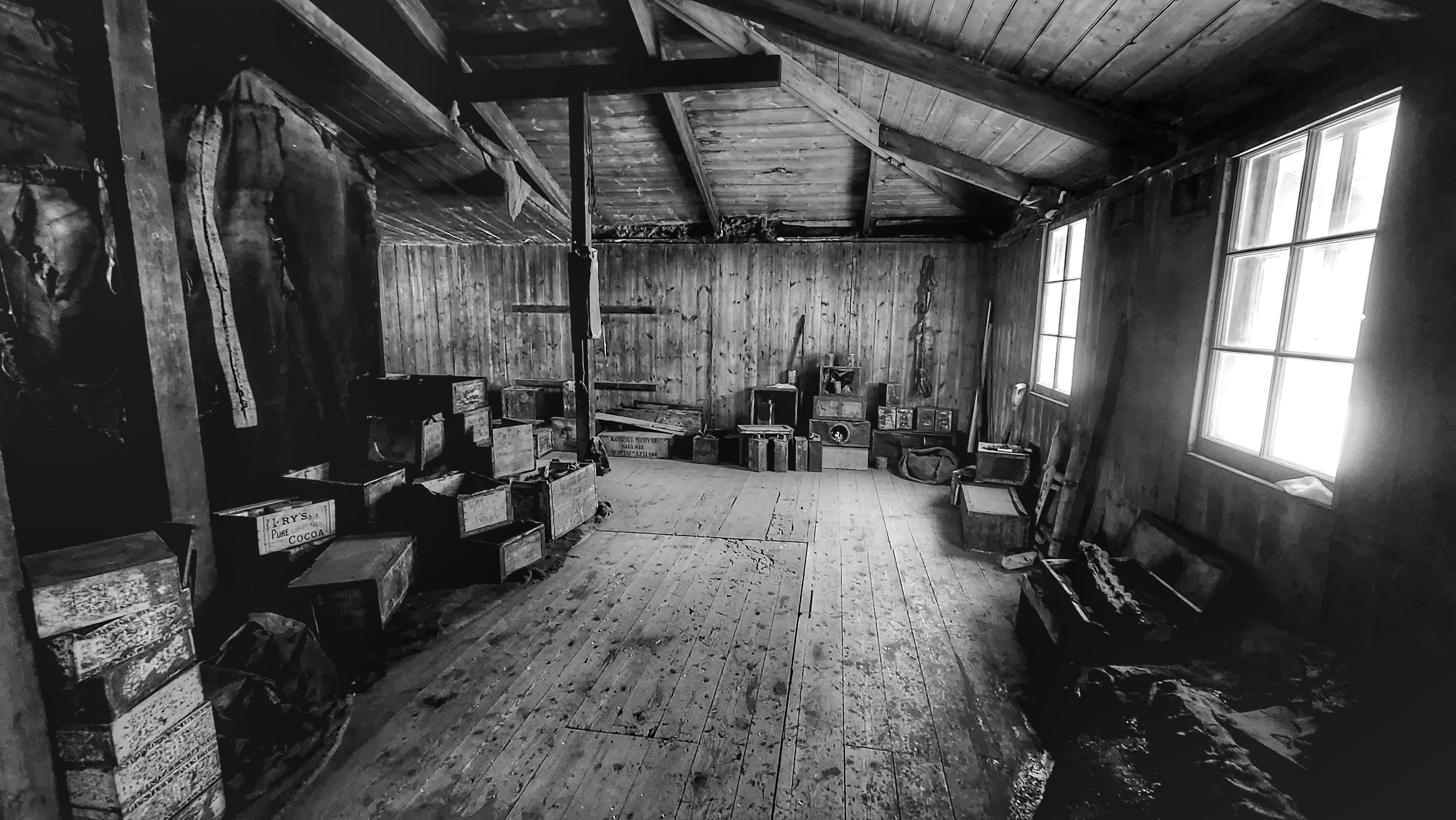 A black and white photo of the inside of an old wooden building.