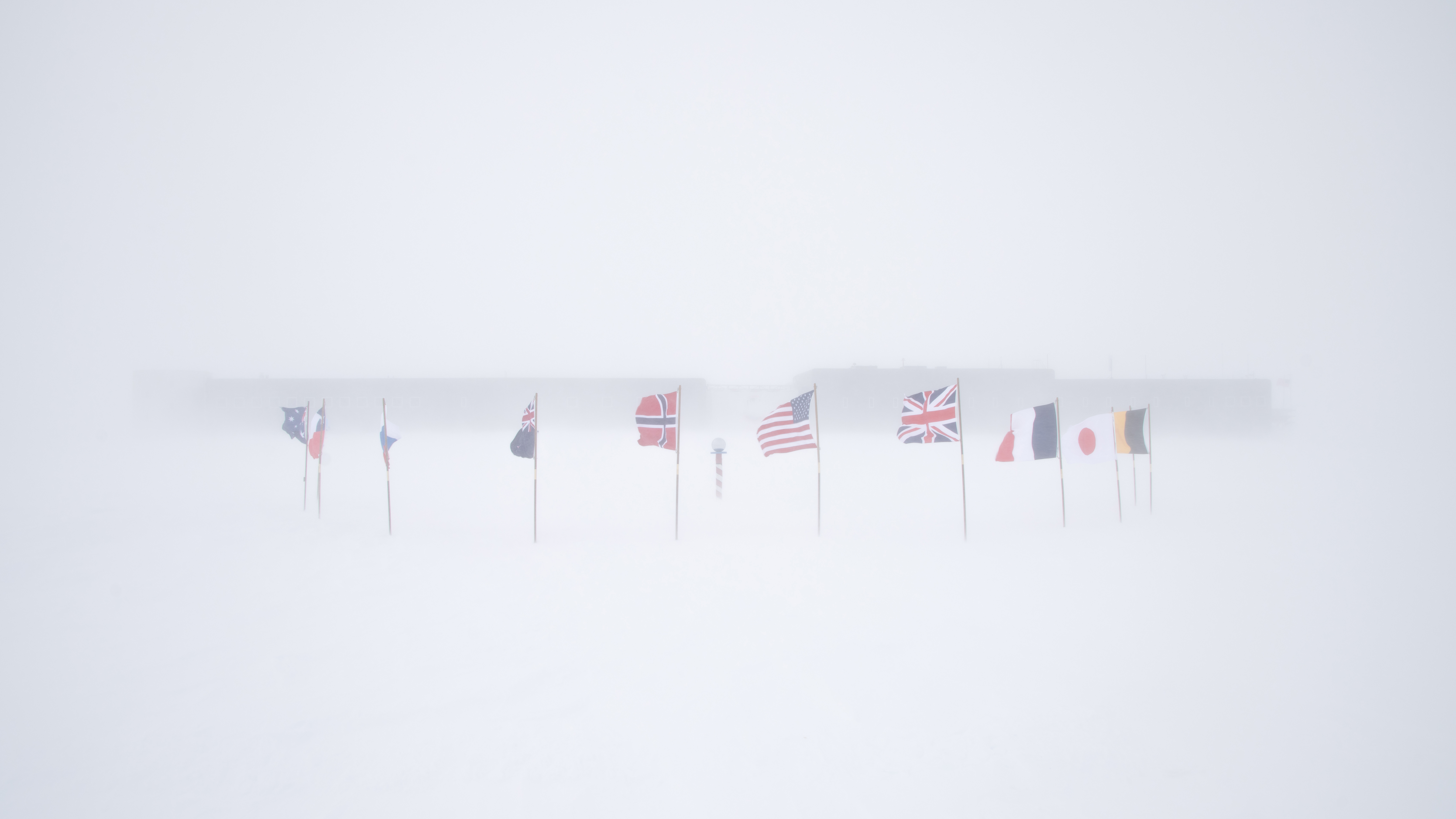 National flags fluttering in a winter snow storm.