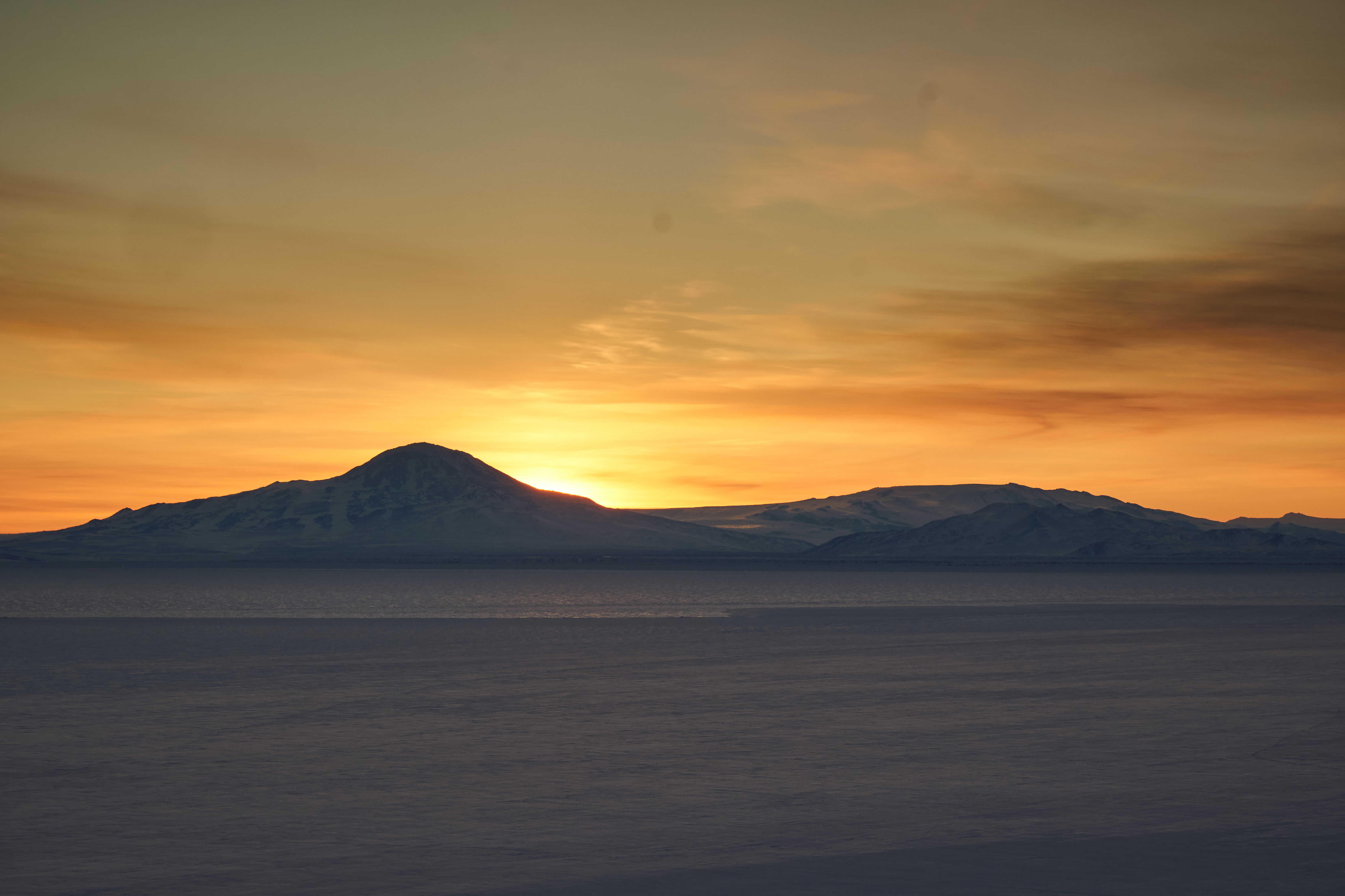 Sunset behind distant hills.