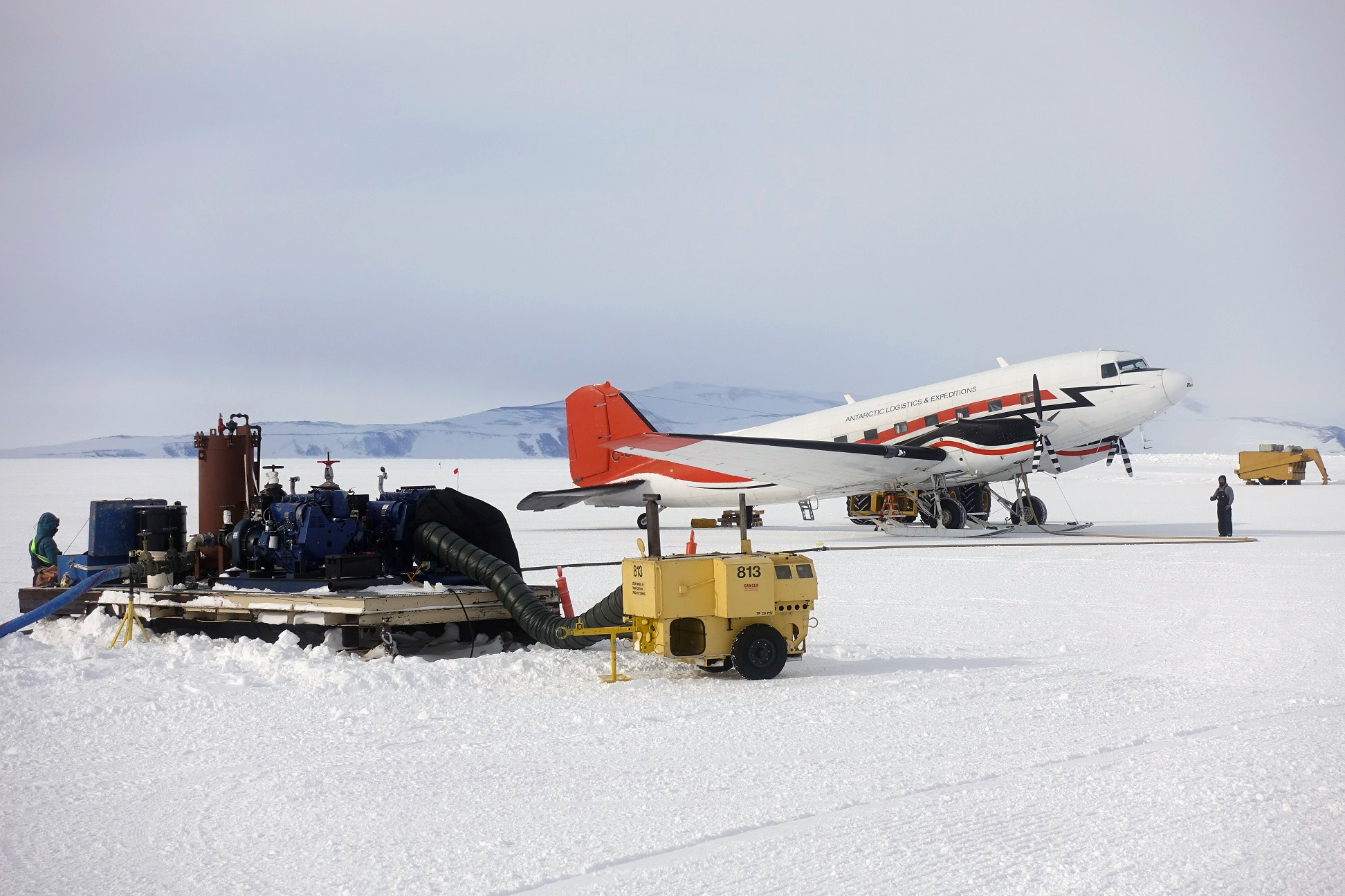 A white airplane on a snowy landscape.