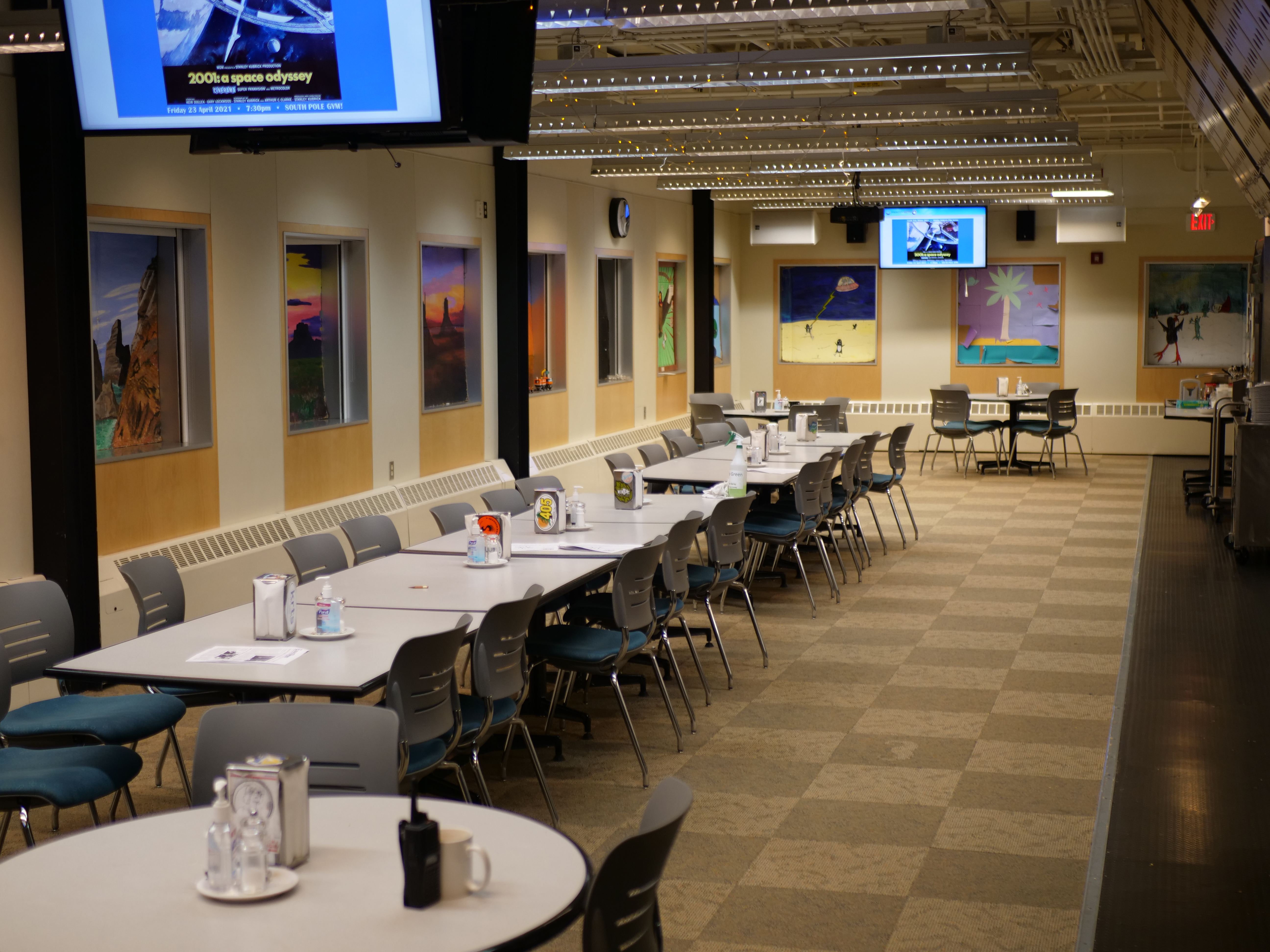 A dining room with colorful paintings on the wall.