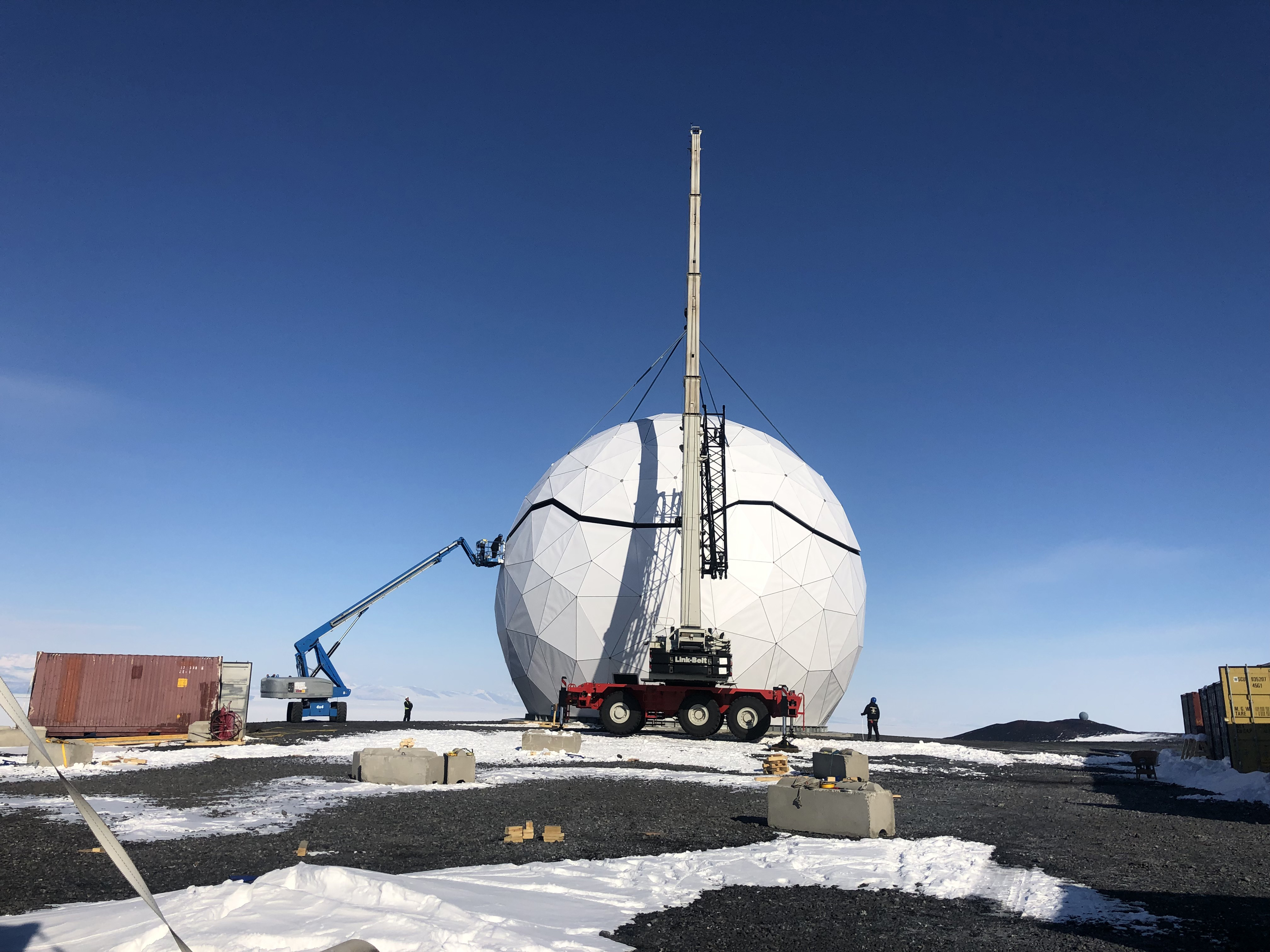 A construction crane working on a geodesic sphere.