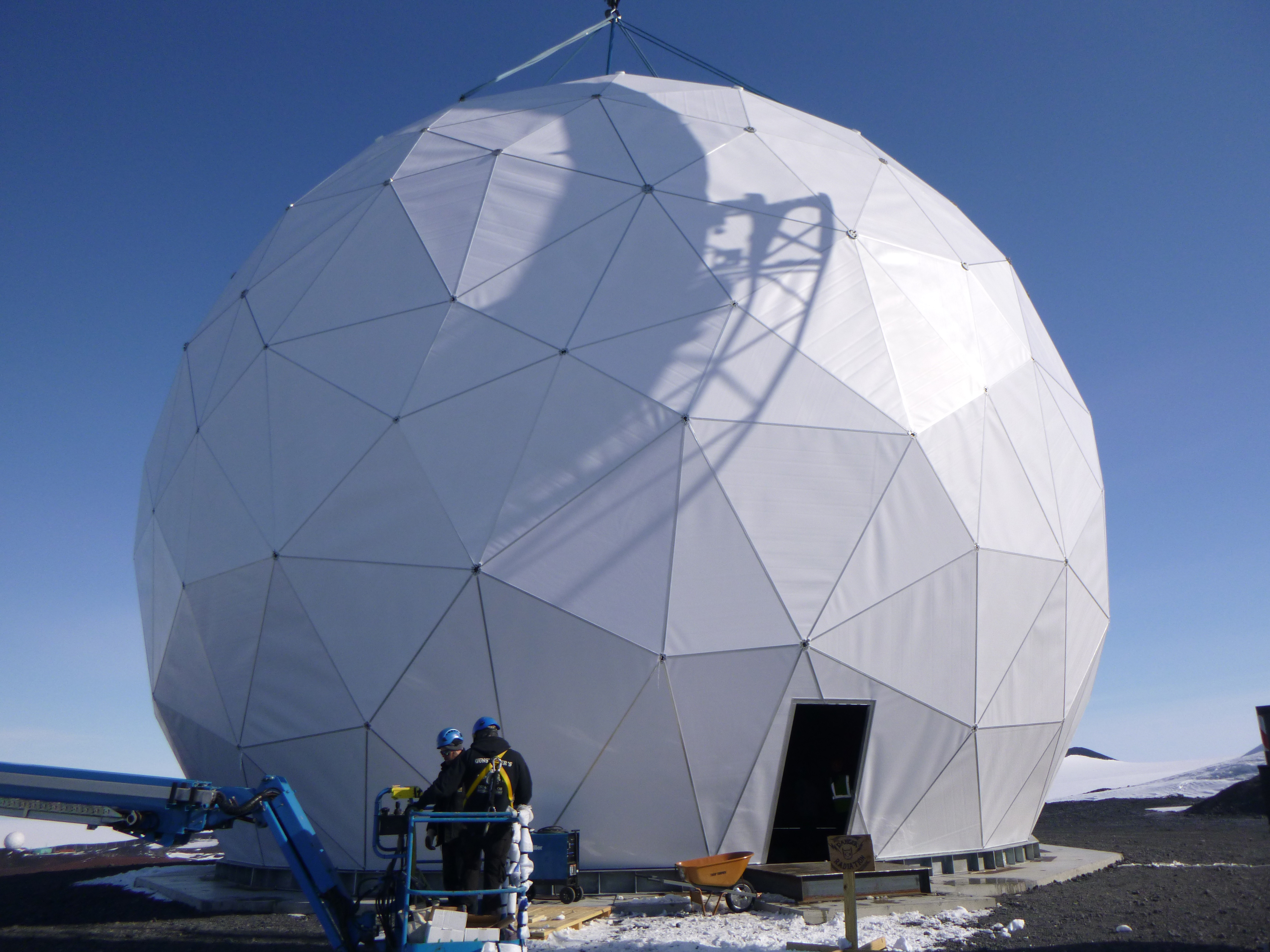 Construction workers near a geodesic dome.