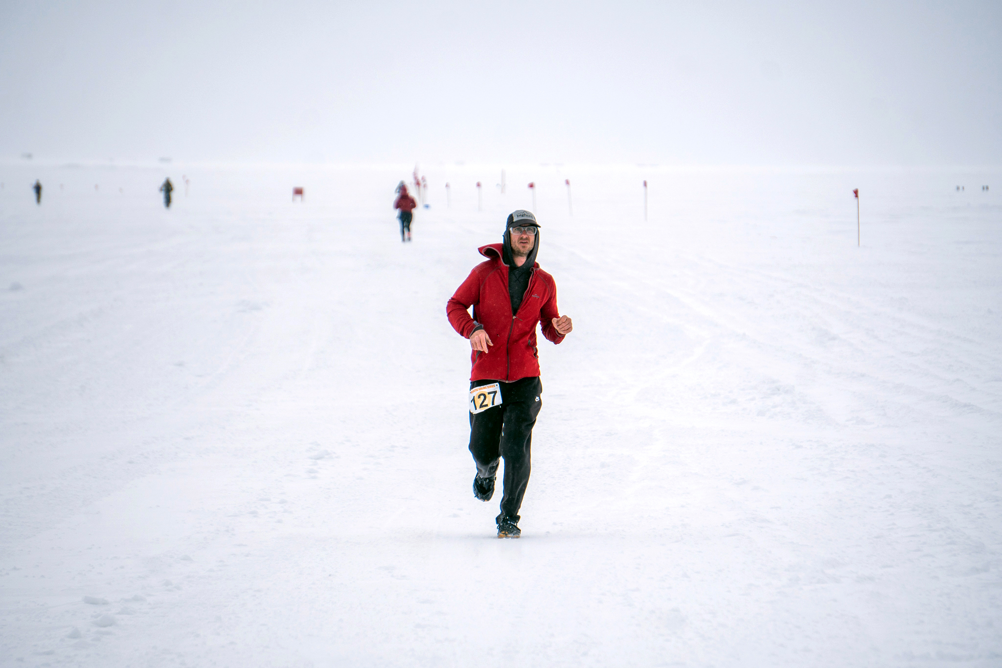 A man runs a race on a snowy day.