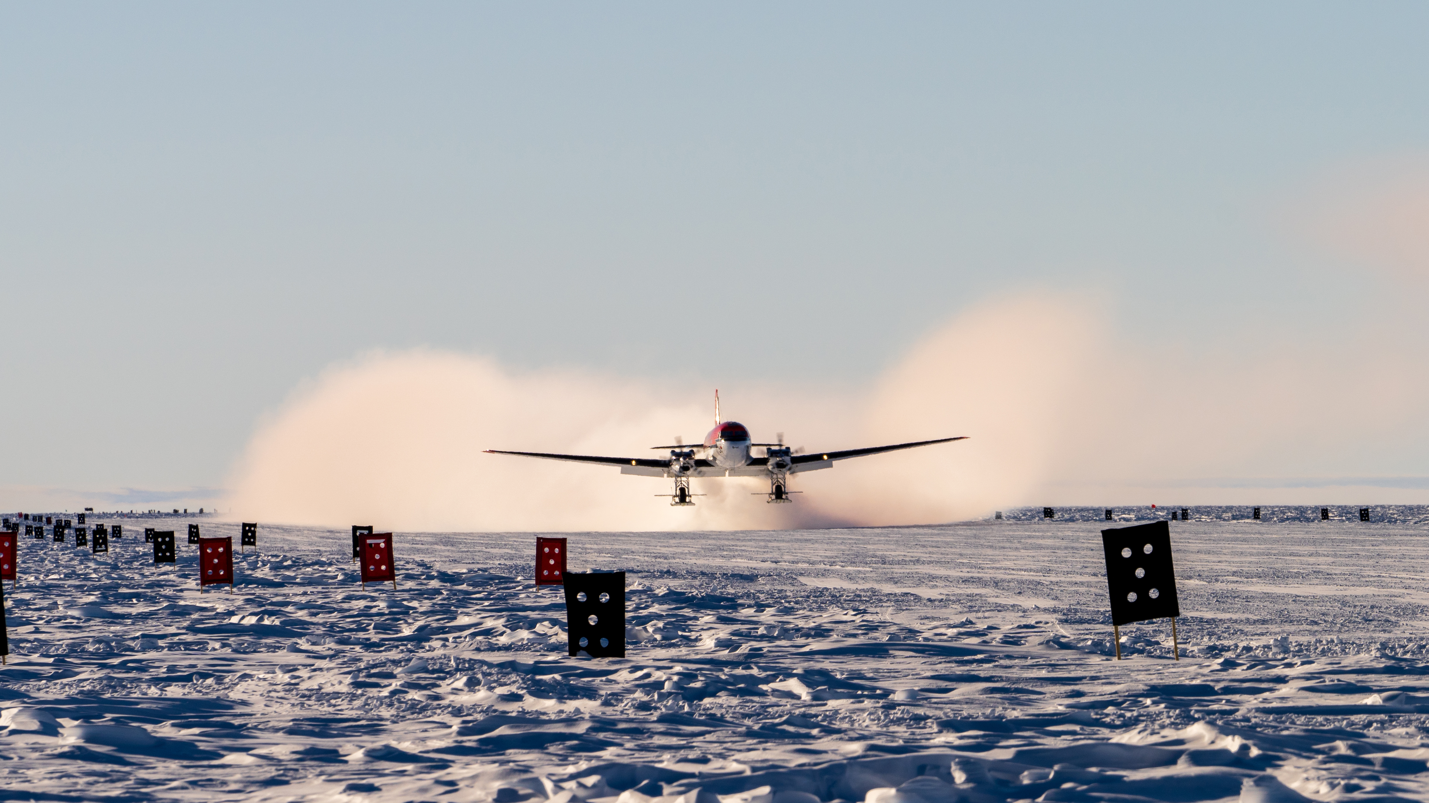 A small airplane landing on snow.