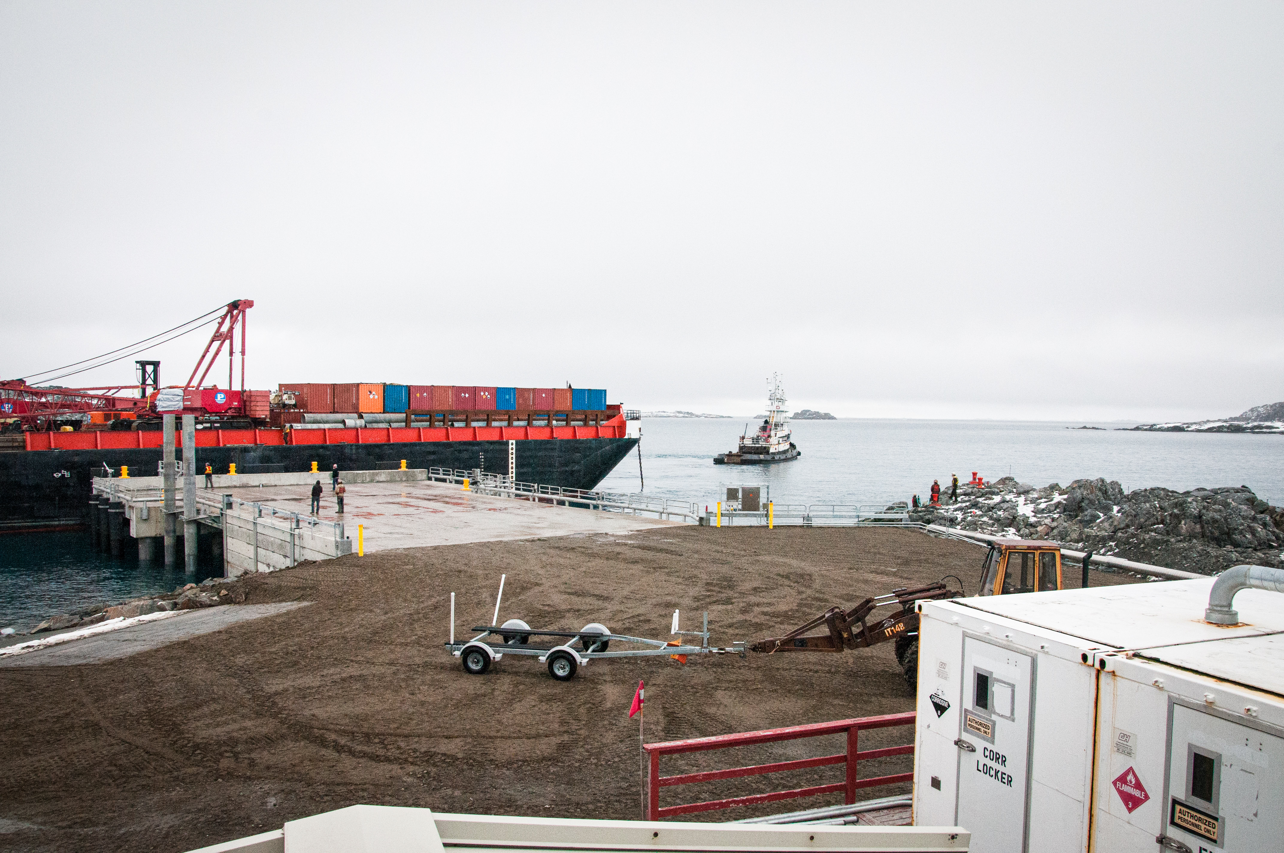 A pier with a barge and harbor in the background. 