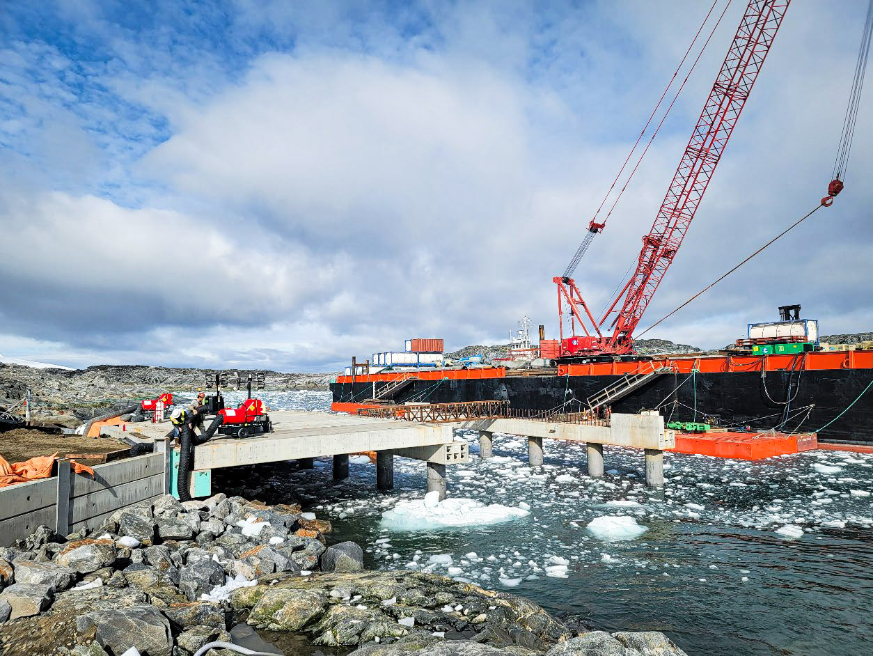 A concrete pier and barge over icy water. 