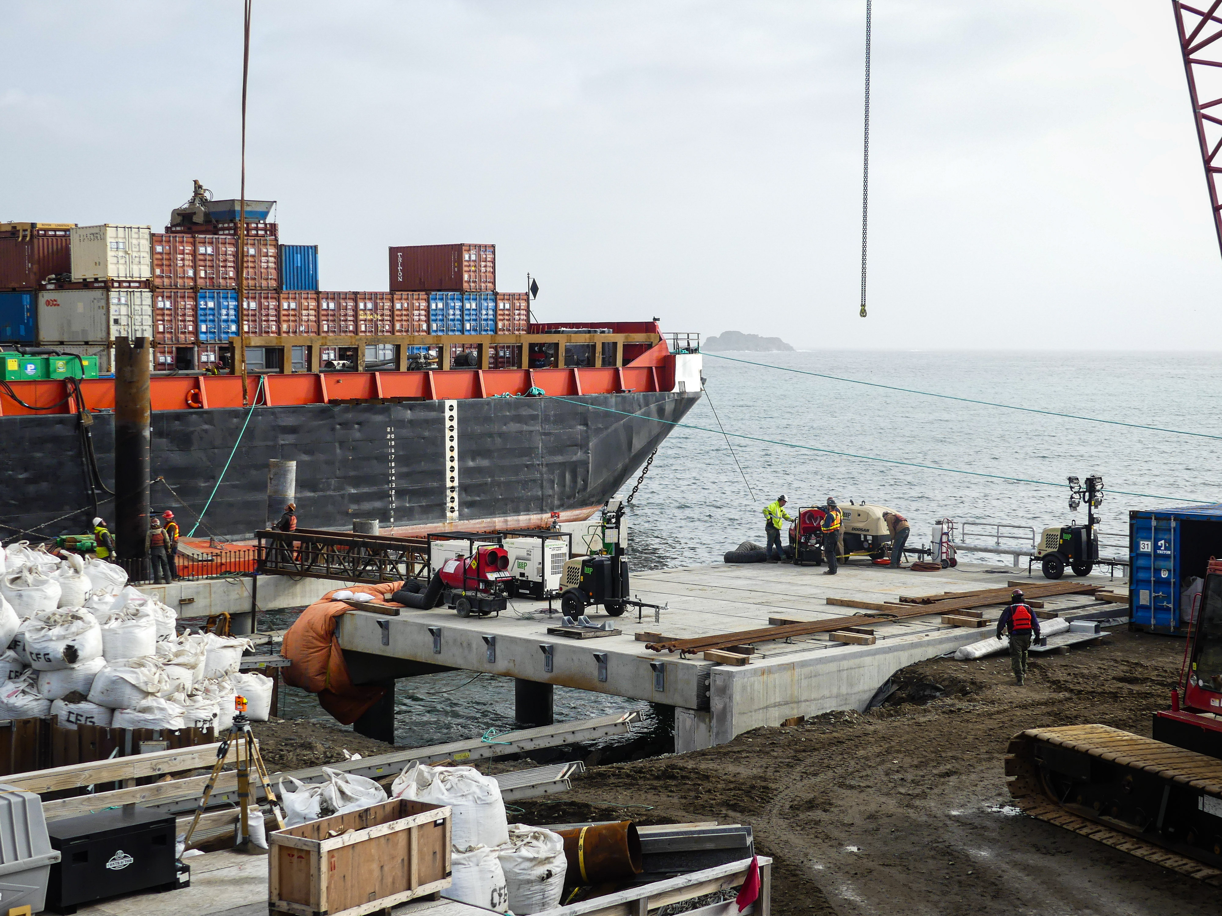 A concrete pier with a barge behind it. 