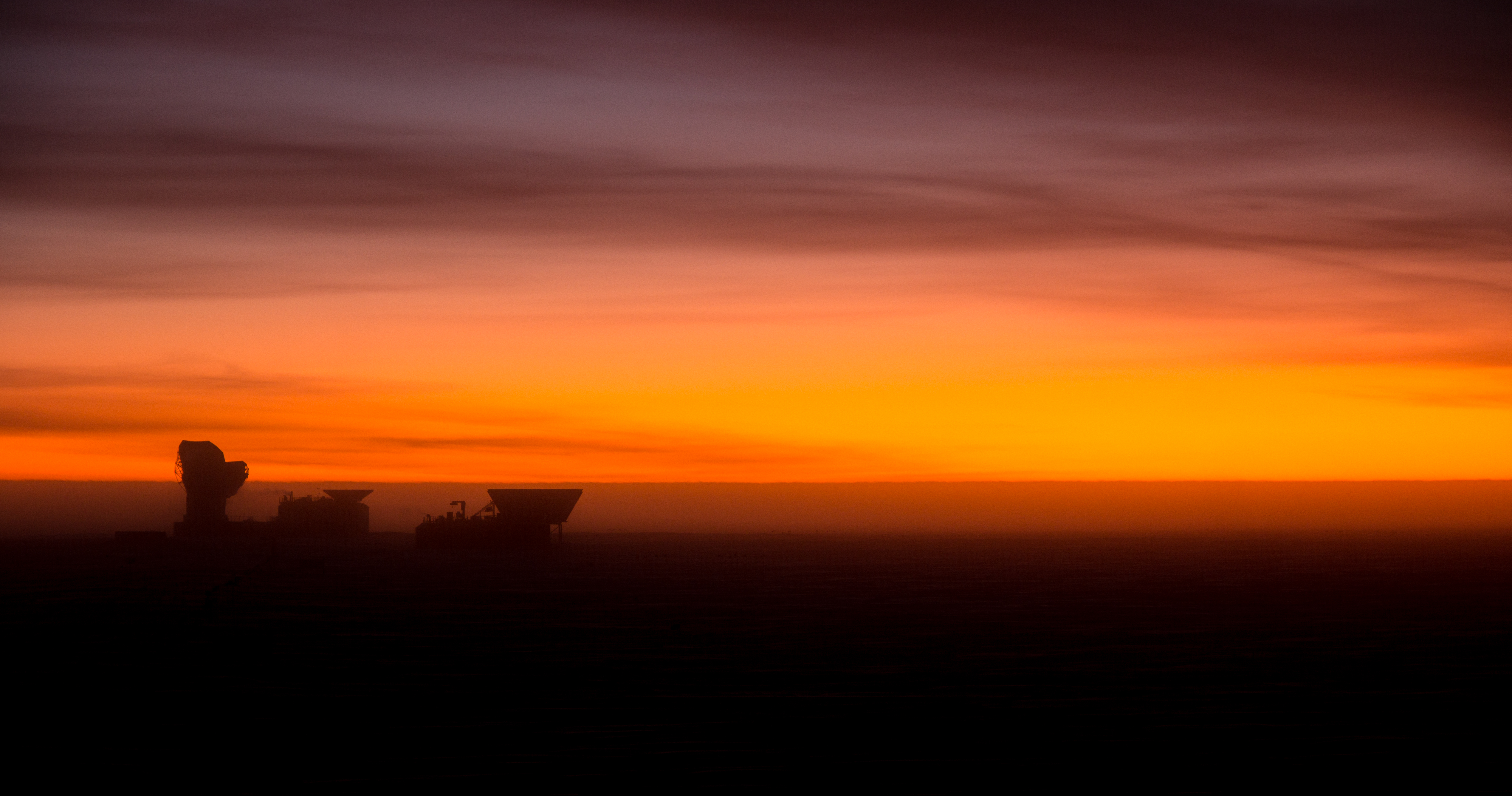 Orange sky at sunset with silhouette of buildings