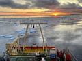 Aft of research ship with sunset over icy waters