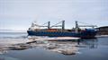 Large cargo ship in icy harbor