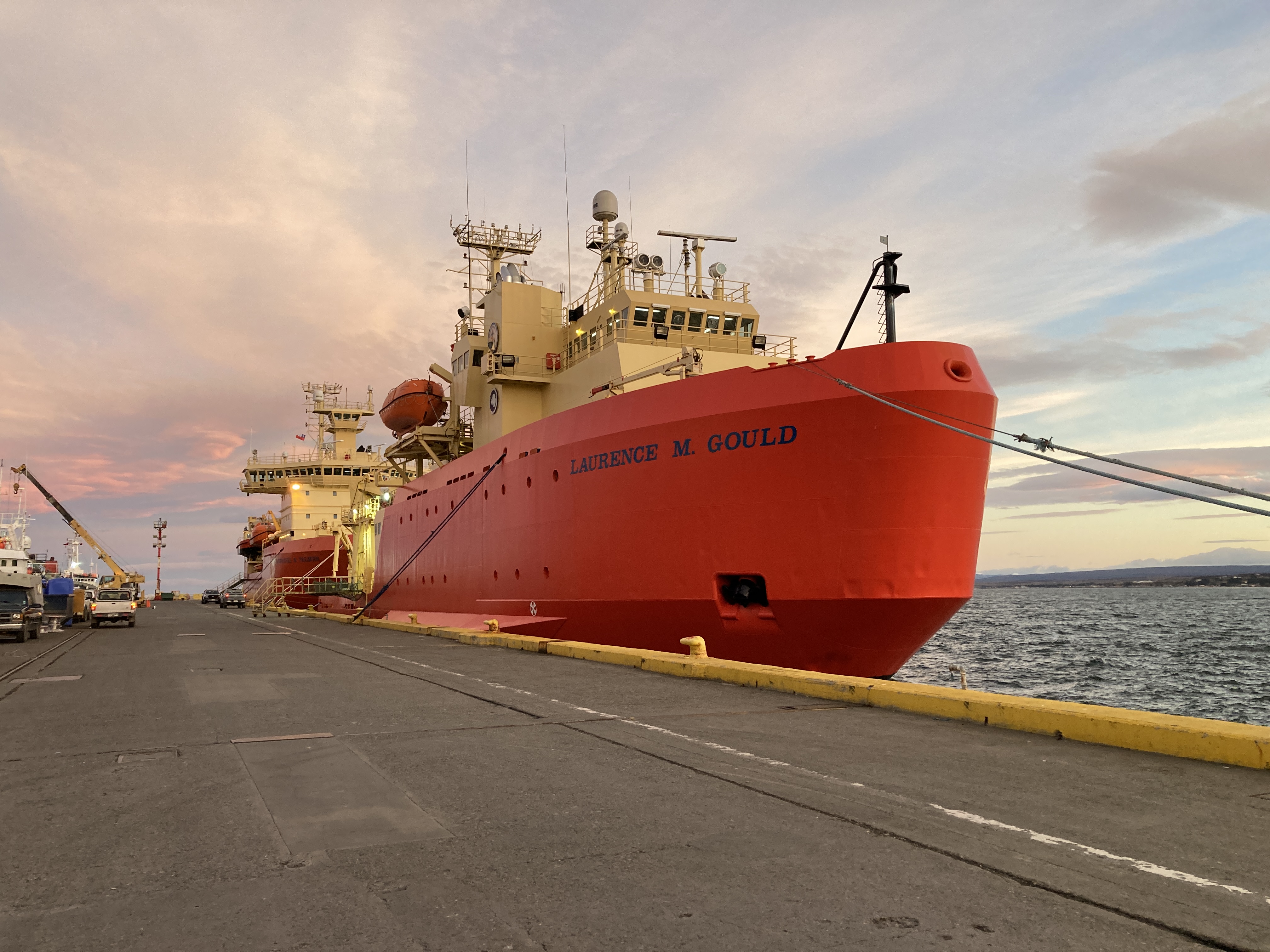 Two large red ships next to a dock