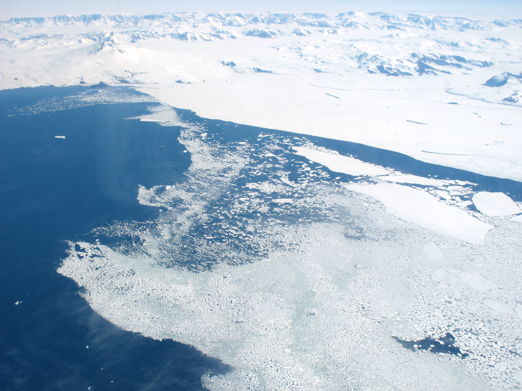 Aerial view of mountains, ice and ocean.