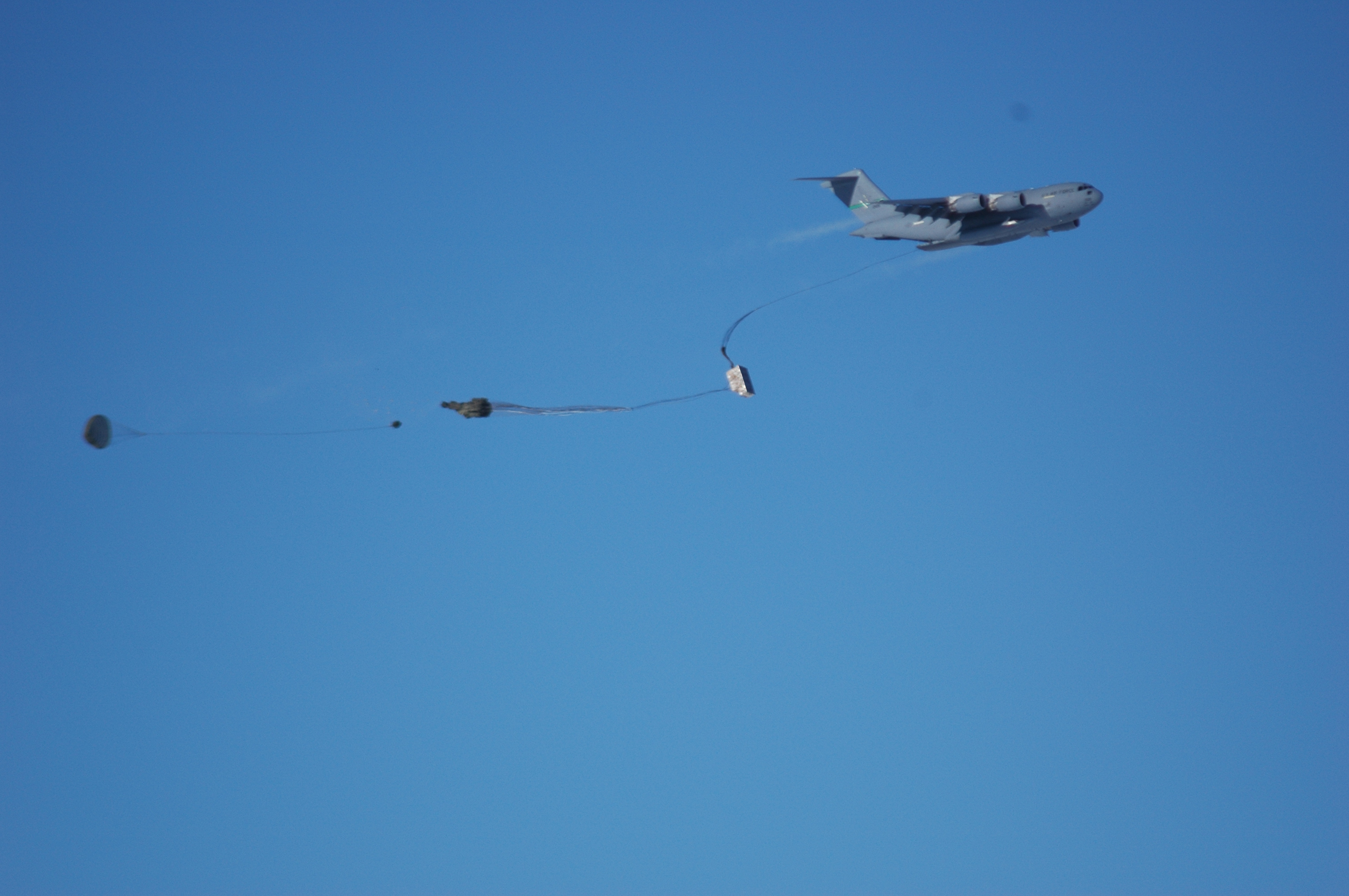 A parachute with cargo is released from an airplane.